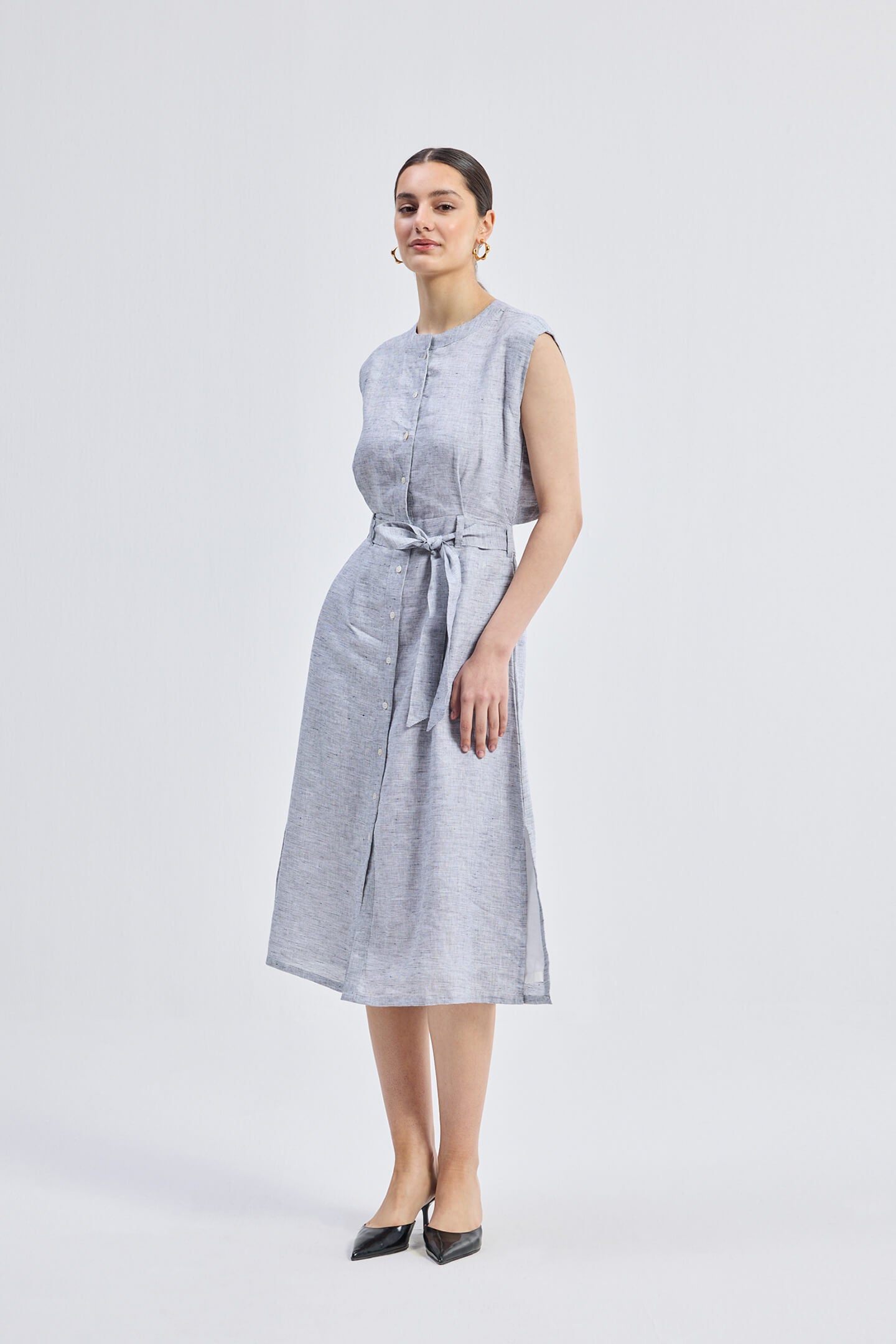 Reisto.r Back Cut Out Linen Dress in grey, front-side view of women’s sleeveless breathable linen midi dress with waist tie belt and relaxed elegant fit.