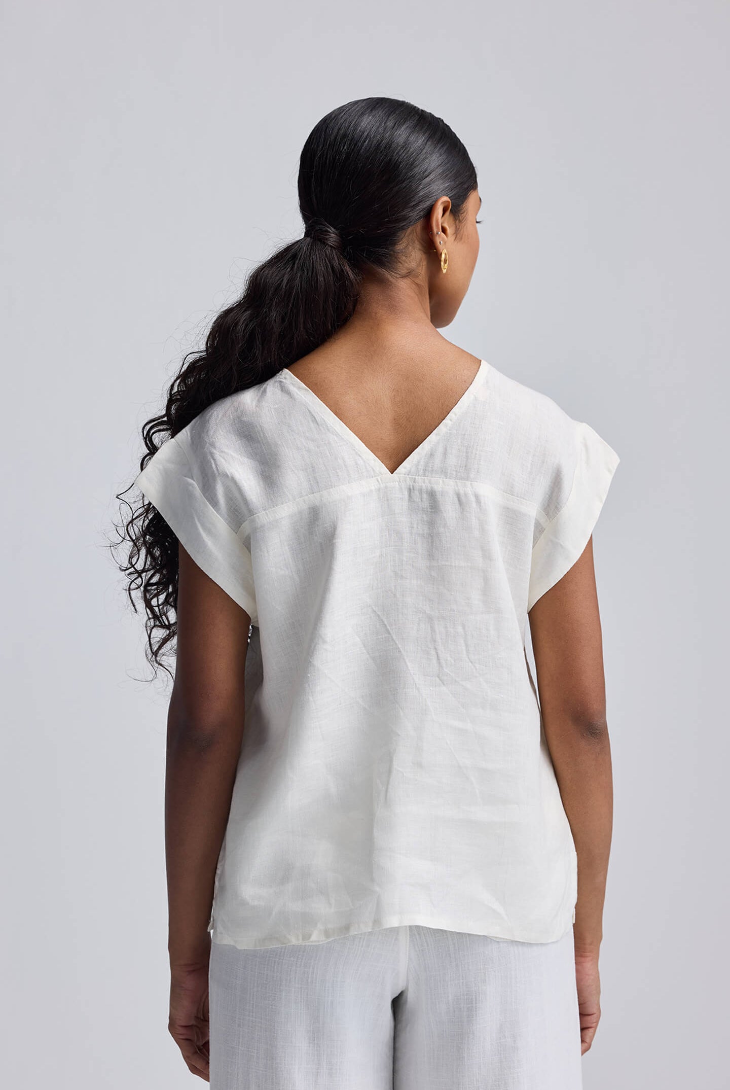Rear view of the Reistor Boxy shirt with Embroidered Lace Detail showing the V-neckline and clean off-white hemp fabric.