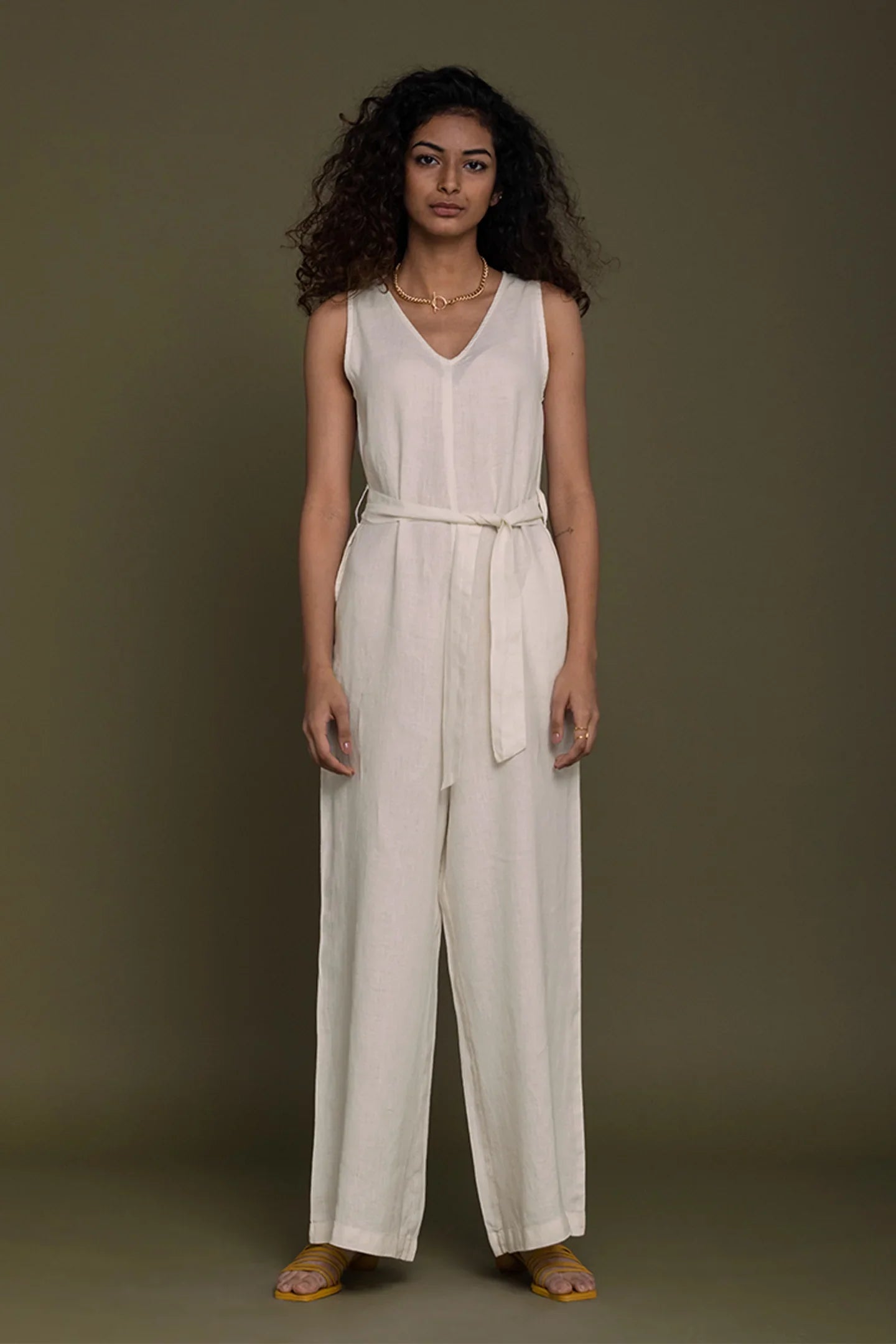 Reistor sleeveless V-neck beige wide-leg jumpsuit with tie waist, sustainable women's fashion for effortless style.