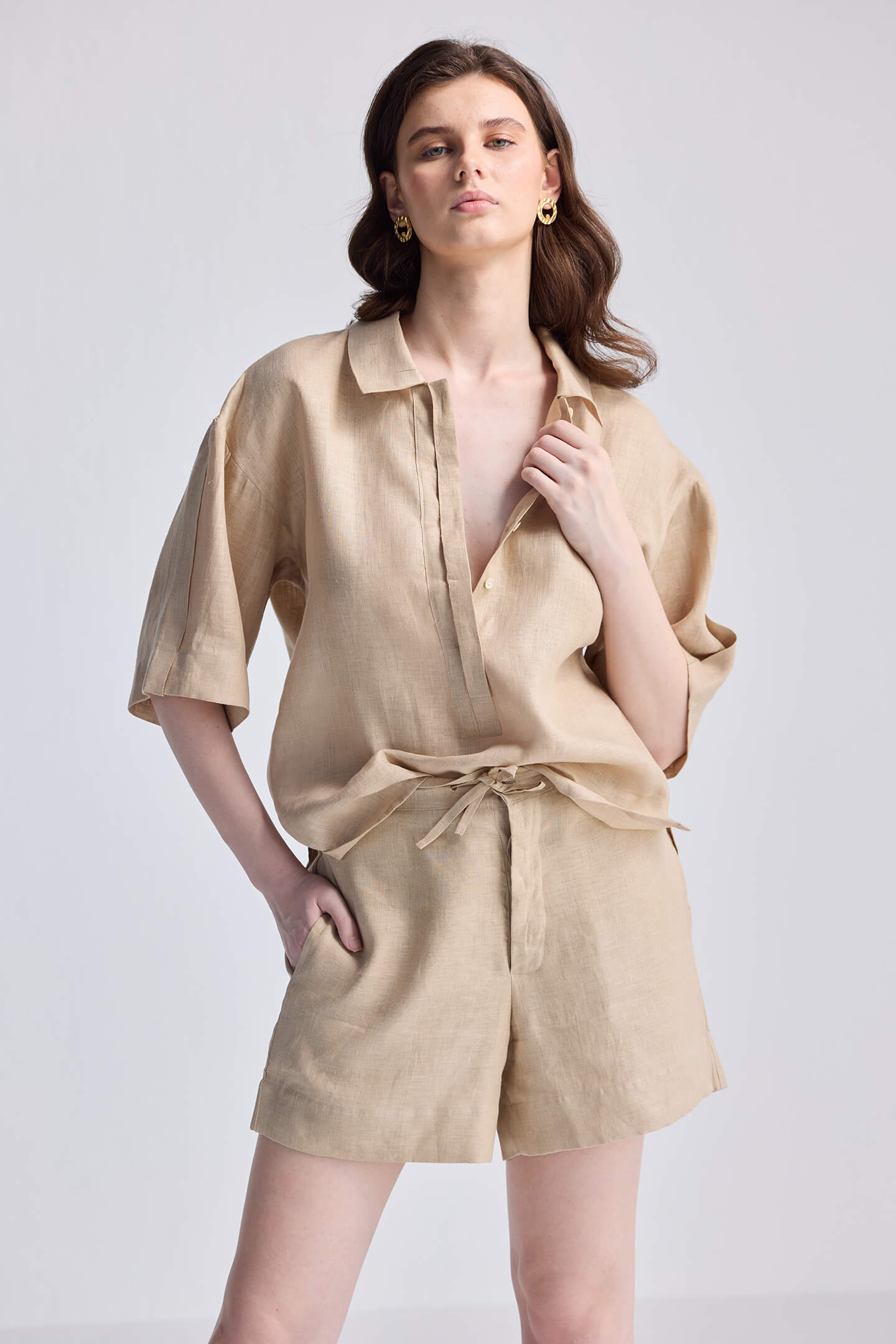 Model wearing reistor Drawstring Shorts in Neutral Beige paired with a matching linen button-down shirt for a coordinated summer look.