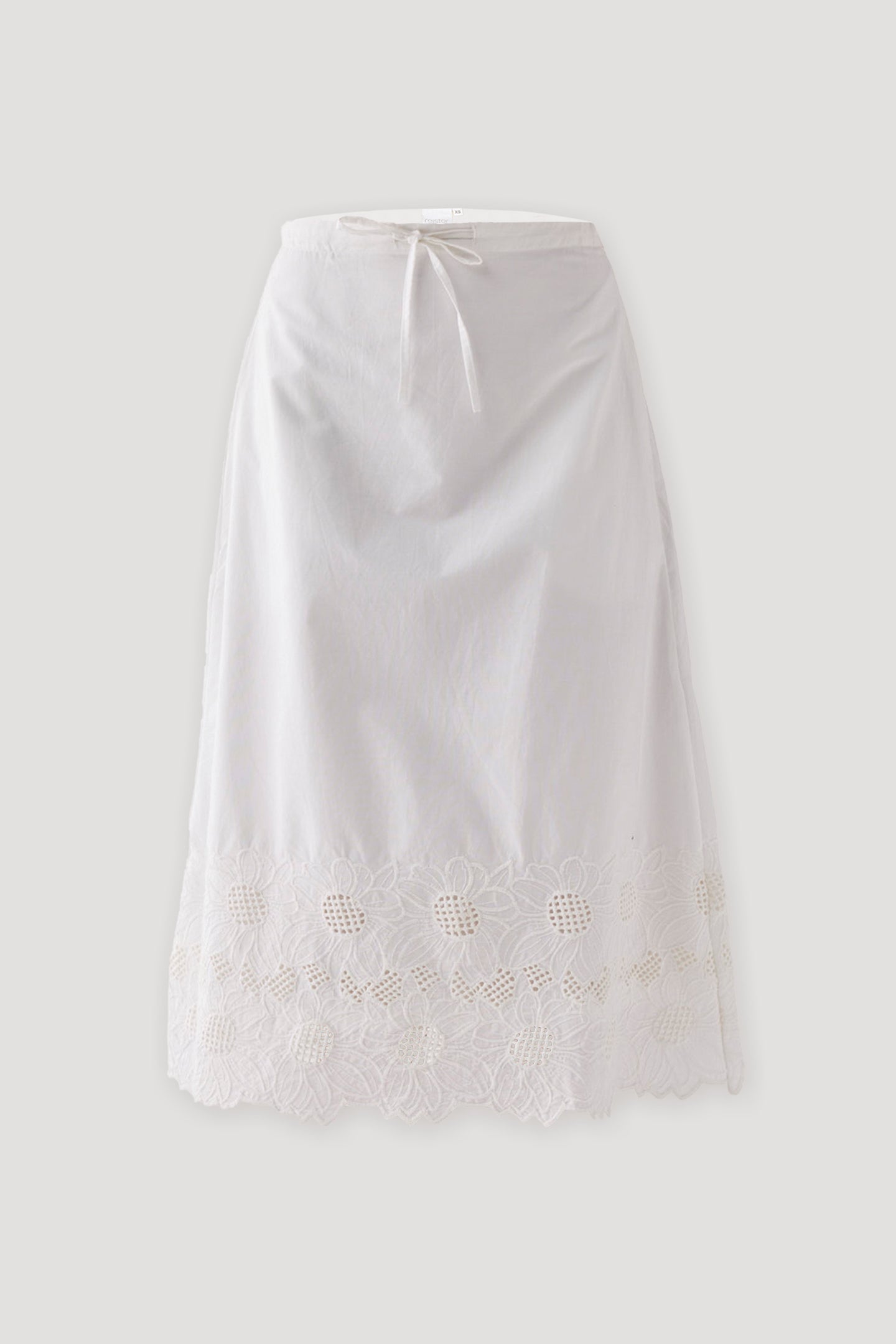 White embroidered midi skirt with a relaxed A-line silhouette, adjustable drawstring waistband, and intricate cutwork embroidery along the scalloped hem, displayed against a light background.