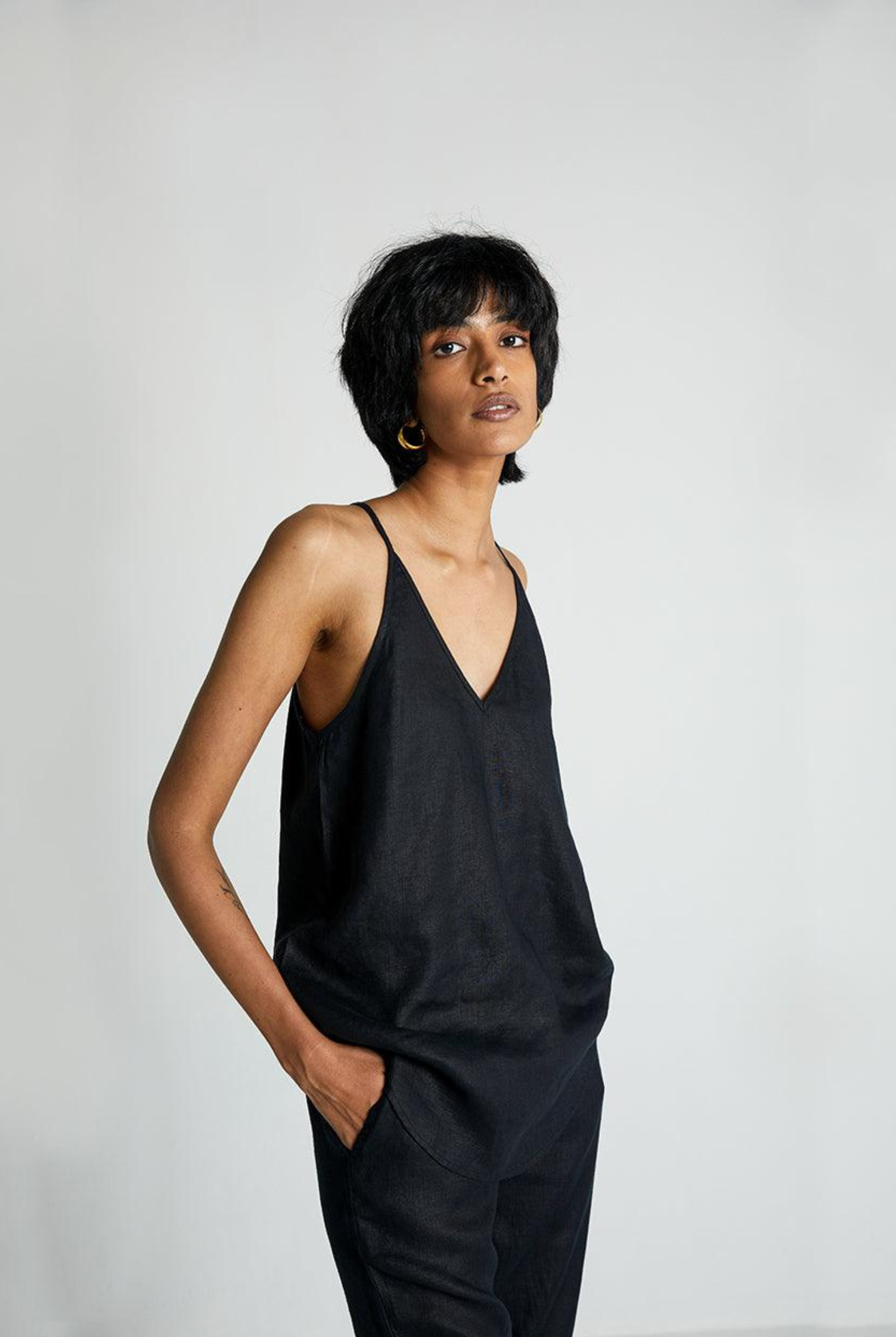 Model wearing Reistor Endless Sunday Top in Black with matching black pants, a sleeveless sustainable top featuring a relaxed fit for effortless everyday style.
