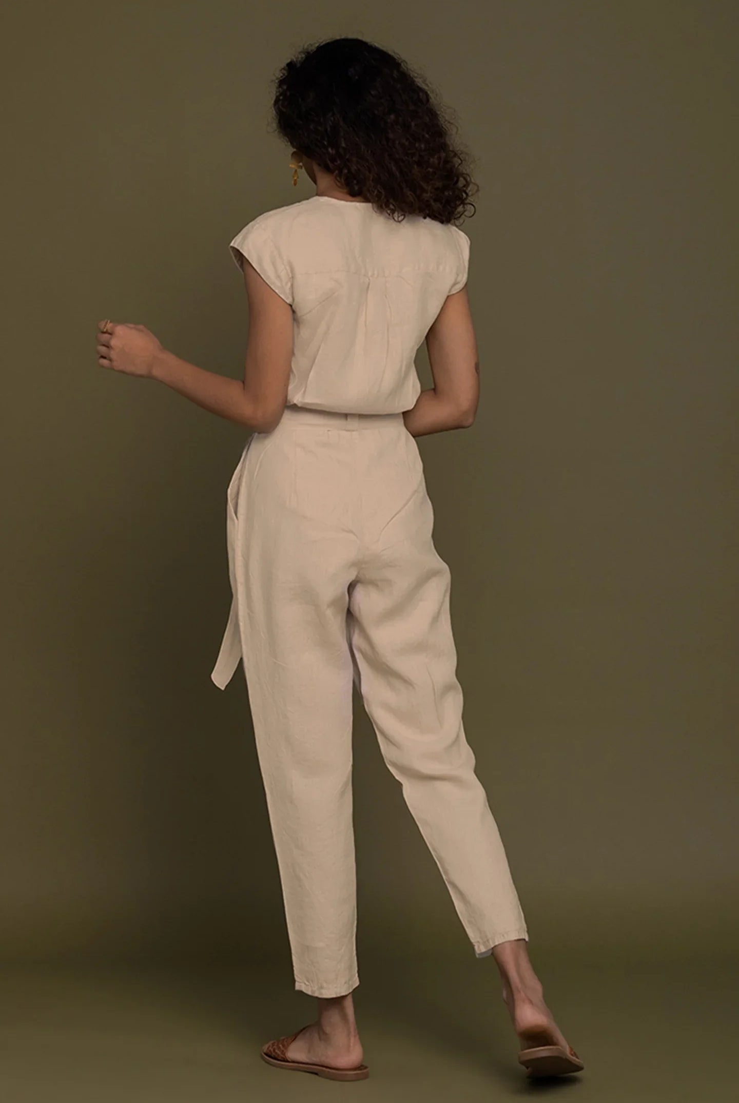 Back view of Reistor Evening Chai Jumpsuit in Neutral Beige with tie waist, timeless sustainable women's fashion.