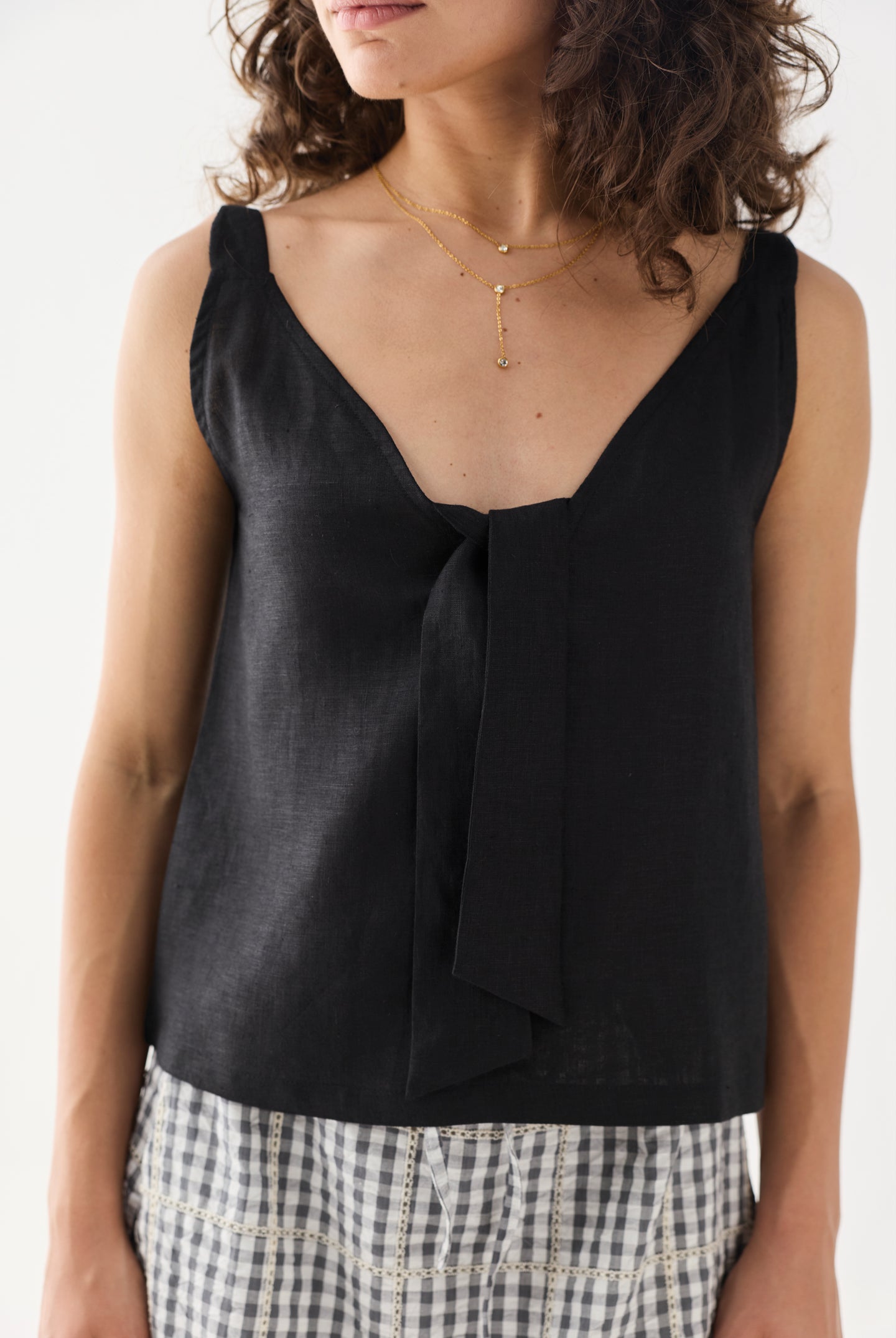Close-up view of the Hemp Front Tie Cami Top in Black, featuring a V-neckline, elegant front tie detail, and a relaxed fit. The lightweight hemp fabric drapes softly for a comfortable, breathable feel.