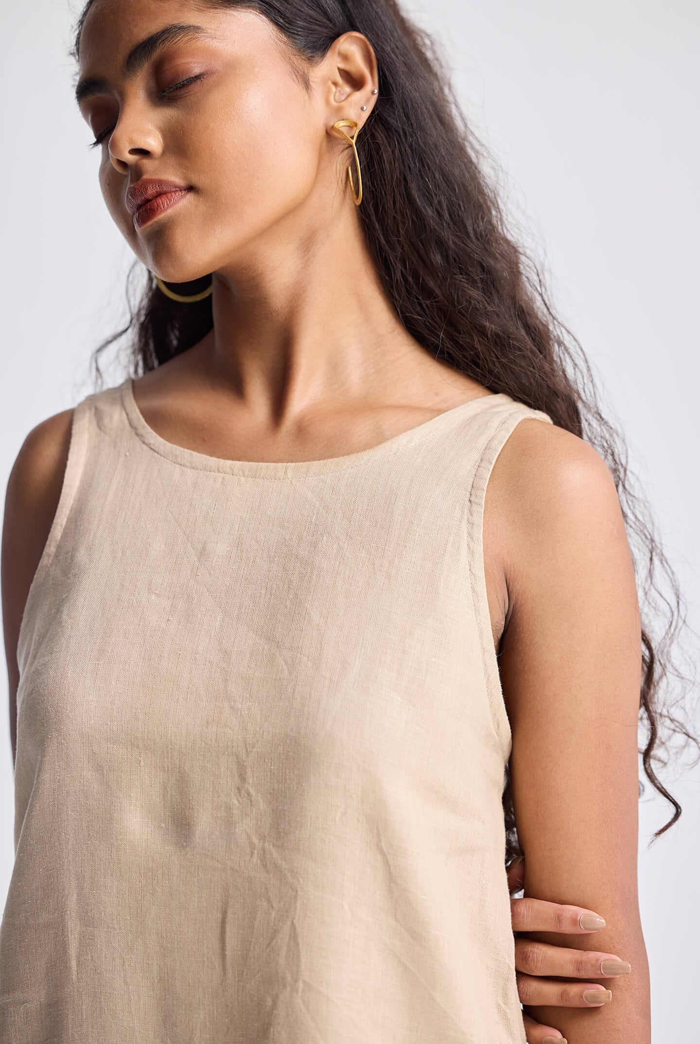 Model wearing Reistor Hemp Short Dress with Back Embroidered Lace Detail in a neutral beige tone, sleeveless design with a soft textured fabric.