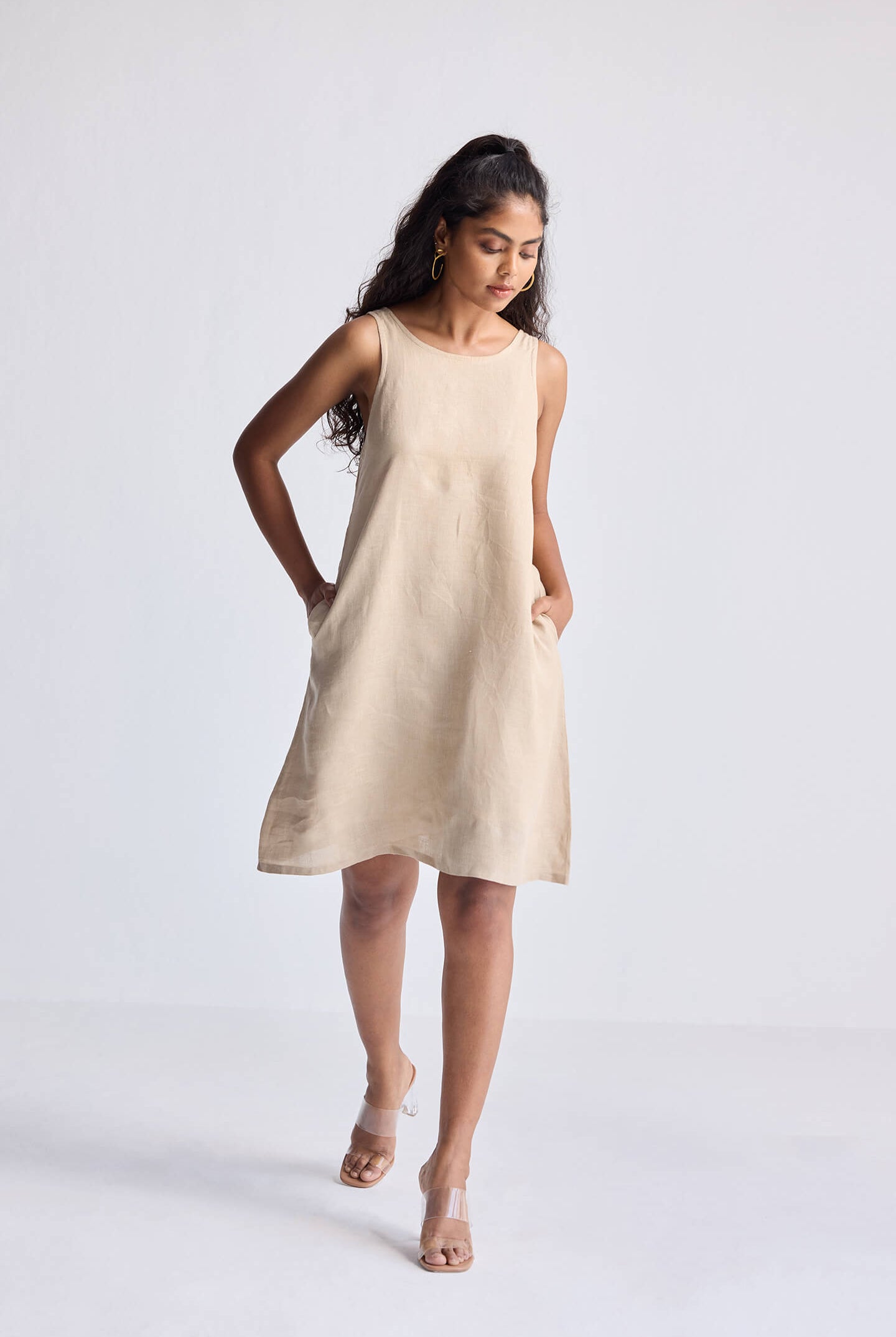 Full-length view of model wearing Reistor Hemp Short Dress with Back Embroidered Lace Detail in a neutral beige shade, sleeveless silhouette with a relaxed fit.