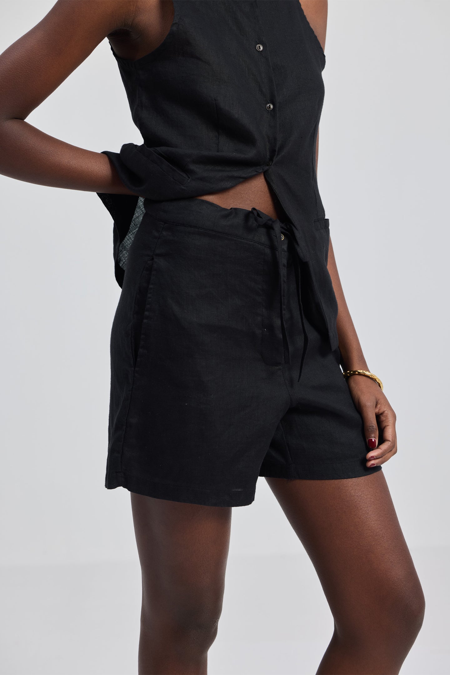 Rear view of a model wearing the reistor Hemp Vest Jacket Set in Black, showcasing the clean sleeveless silhouette of the vest and the tailored fit of the matching sustainable hemp shorts.