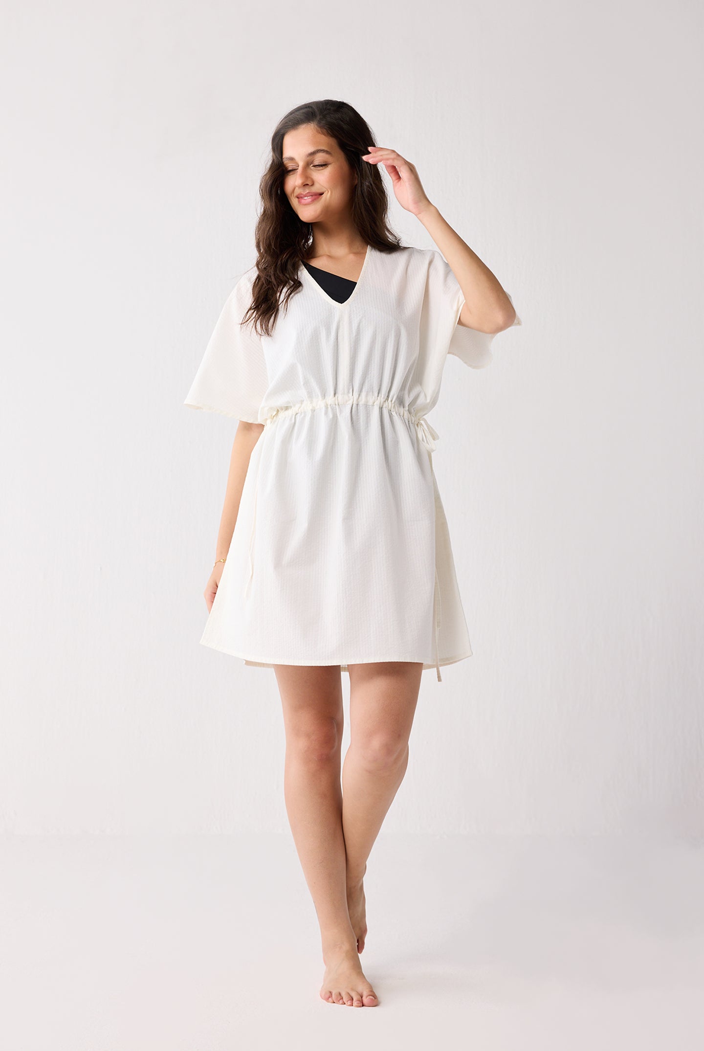 Woman wearing a white dress on a plain background
