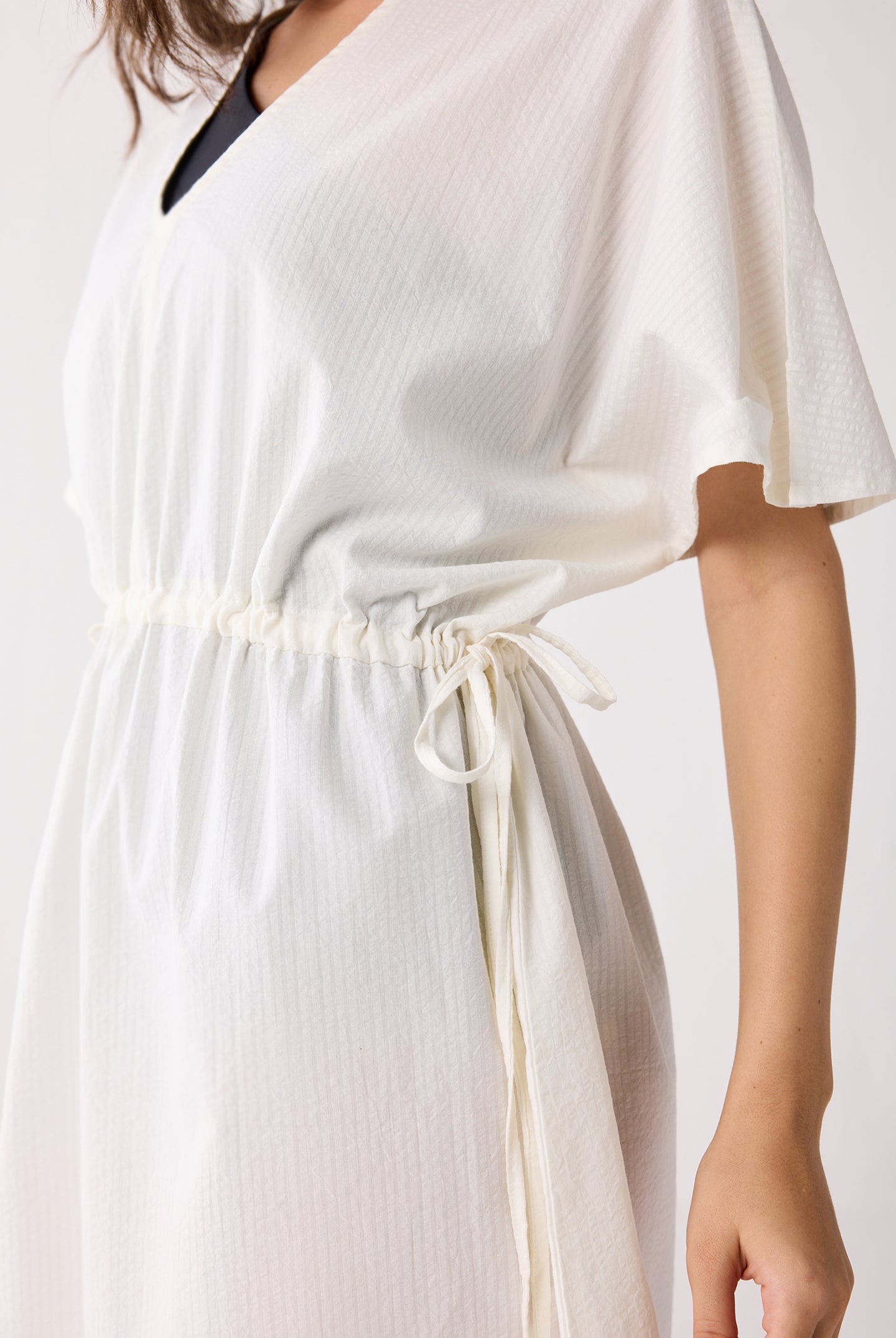 White dress with a drawstring waist on a plain background