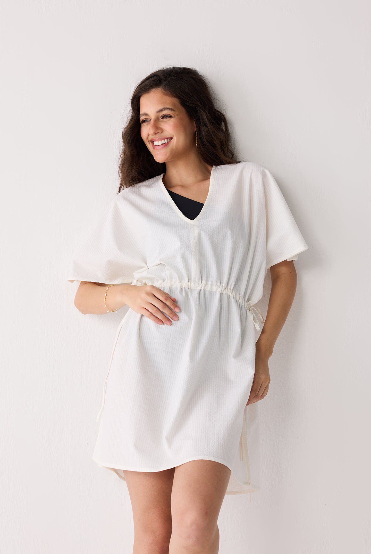 Woman wearing a white dress against a plain background