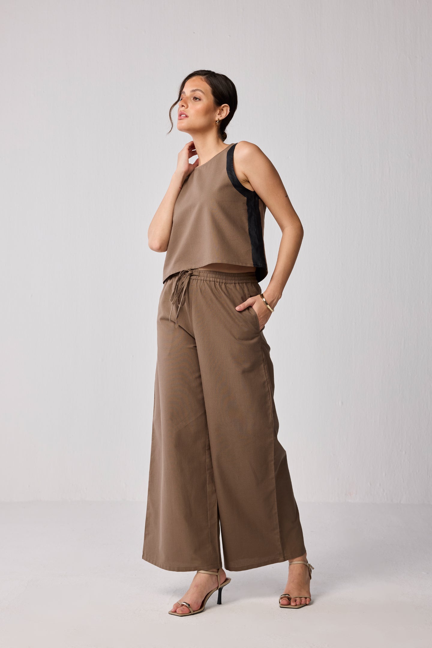 Model wearing a Reistor Matching Set with Wide-leg Pants and Colorblock Top in Brown, featuring a sleeveless brown top with black side panels and coordinating relaxed-fit drawstring trousers.