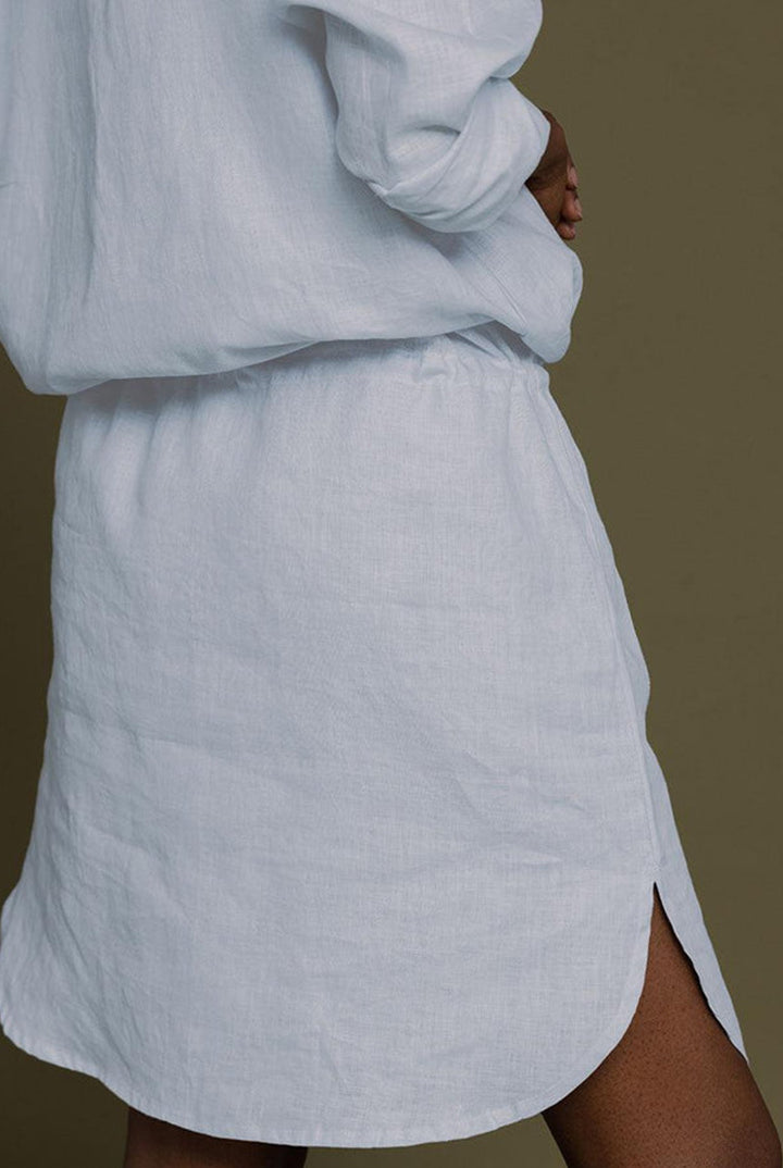 Meet Me by the Cliff Dress in Blue by Reistor, close-up back view with curved hem and side slit on a blue shirt dress