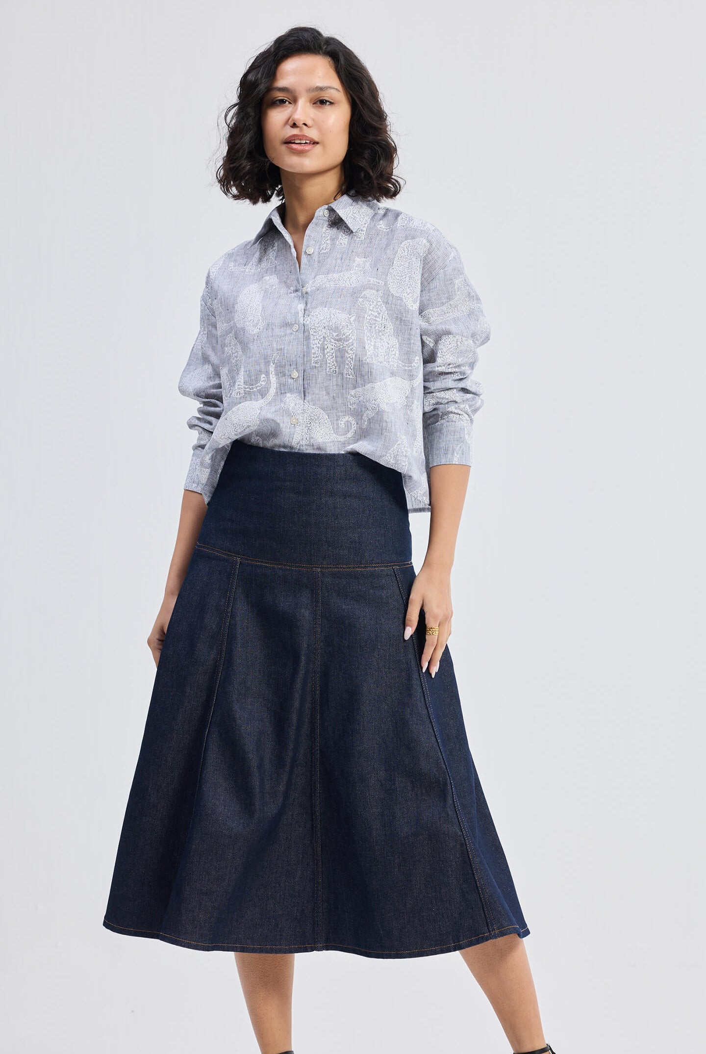 reistor Oversized Boxy-fit Shirt in Animal Print, front angled view styled with denim midi skirt and wedge sandals