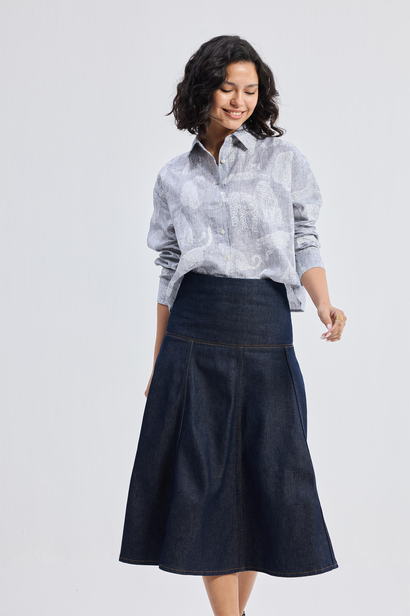 reistor Oversized Boxy-fit Shirt in Animal Print, model walking pose styled with denim midi skirt and wedge sandals