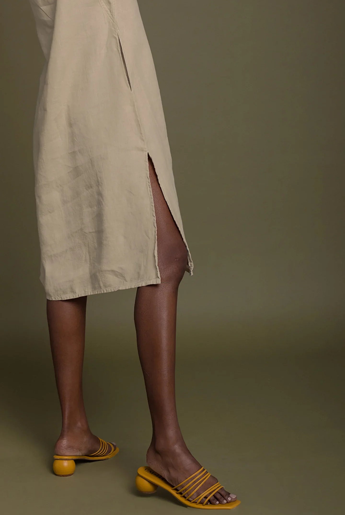 Detail view of Reistor Reading Tea Leaves Dress in Neutral Beige, showcasing the side slit and midi-length design.