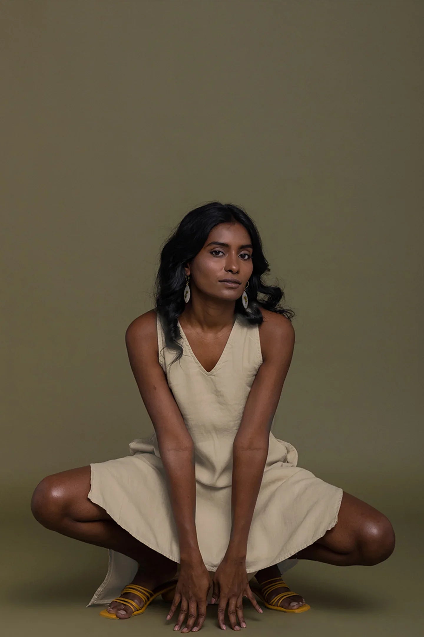 Reistor Reading Tea Leaves Dress in Neutral Beige, sleeveless V-neck sustainable dress with a relaxed fit and elegant pose.