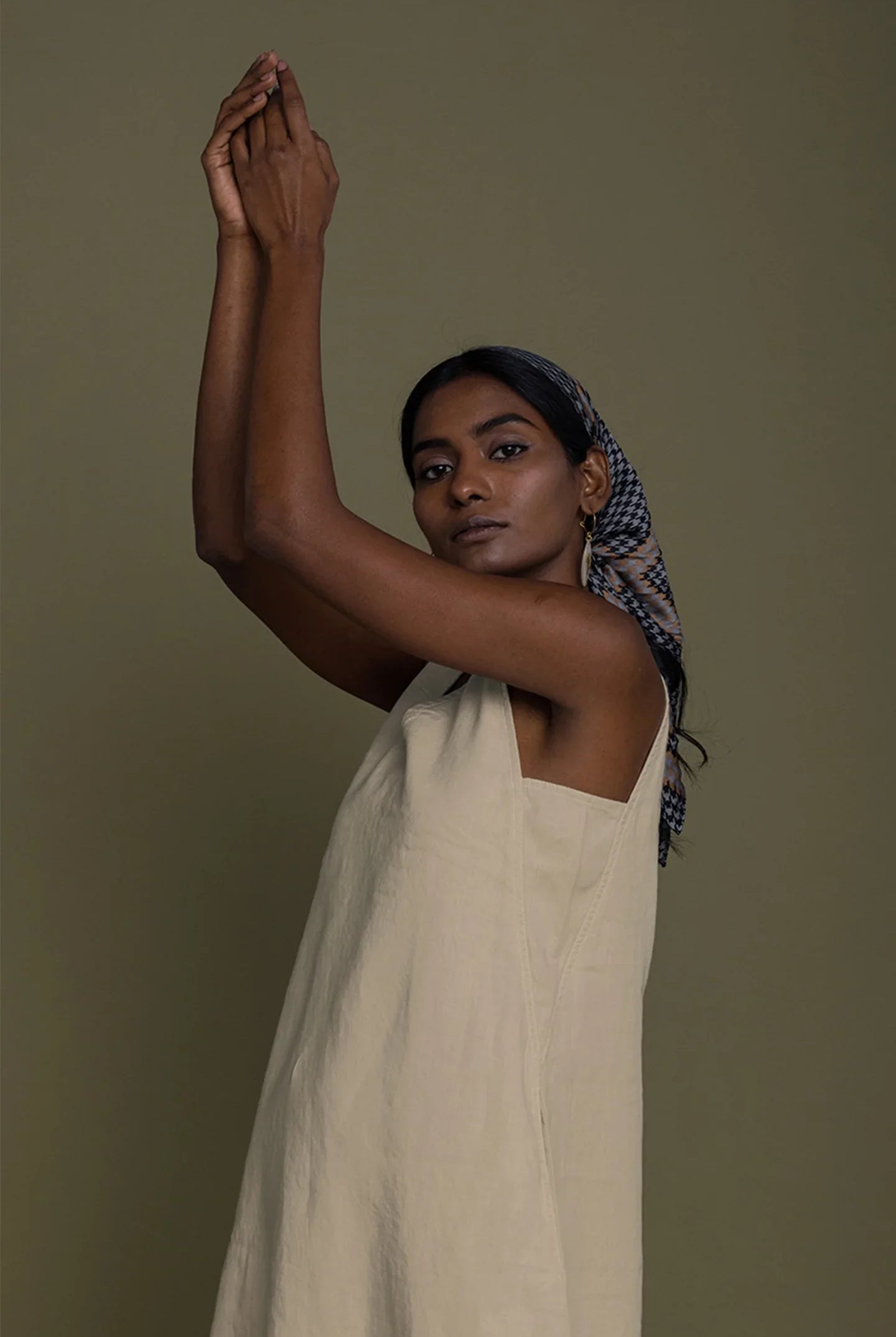 Woman wearing Reistor Reading Tea Leaves Dress in Neutral Beige, relaxed sleeveless midi dress in a portrait pose.