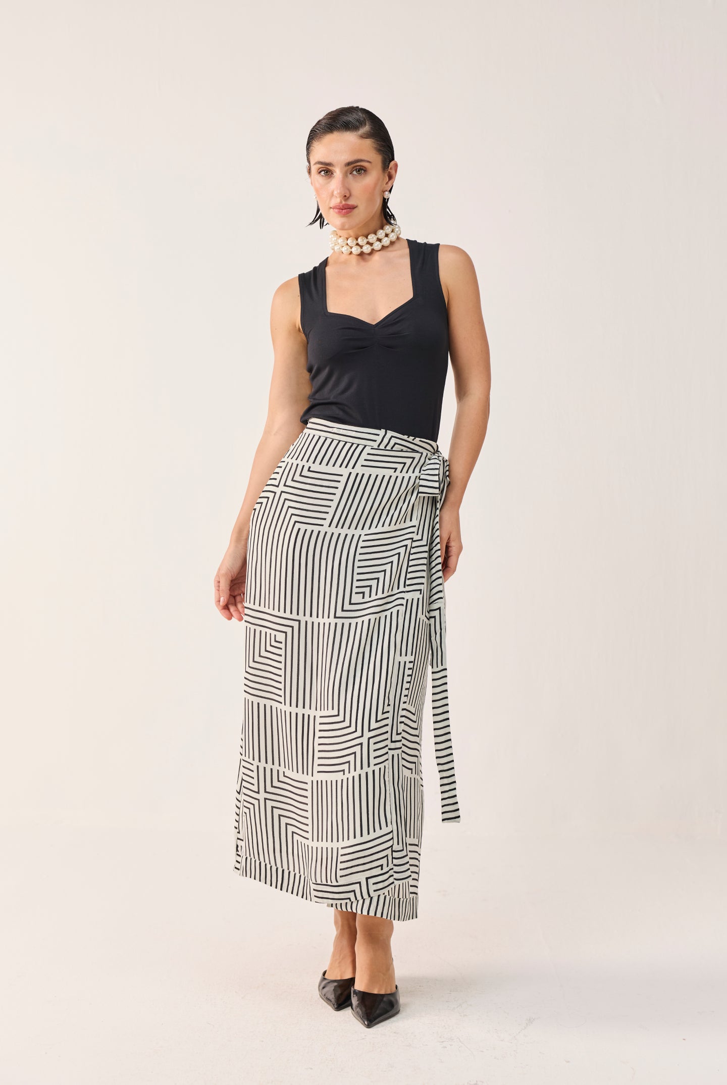 Front view of Reistor Regular Sweetheart Neck Top in Black paired with a black and white patterned midi skirt.