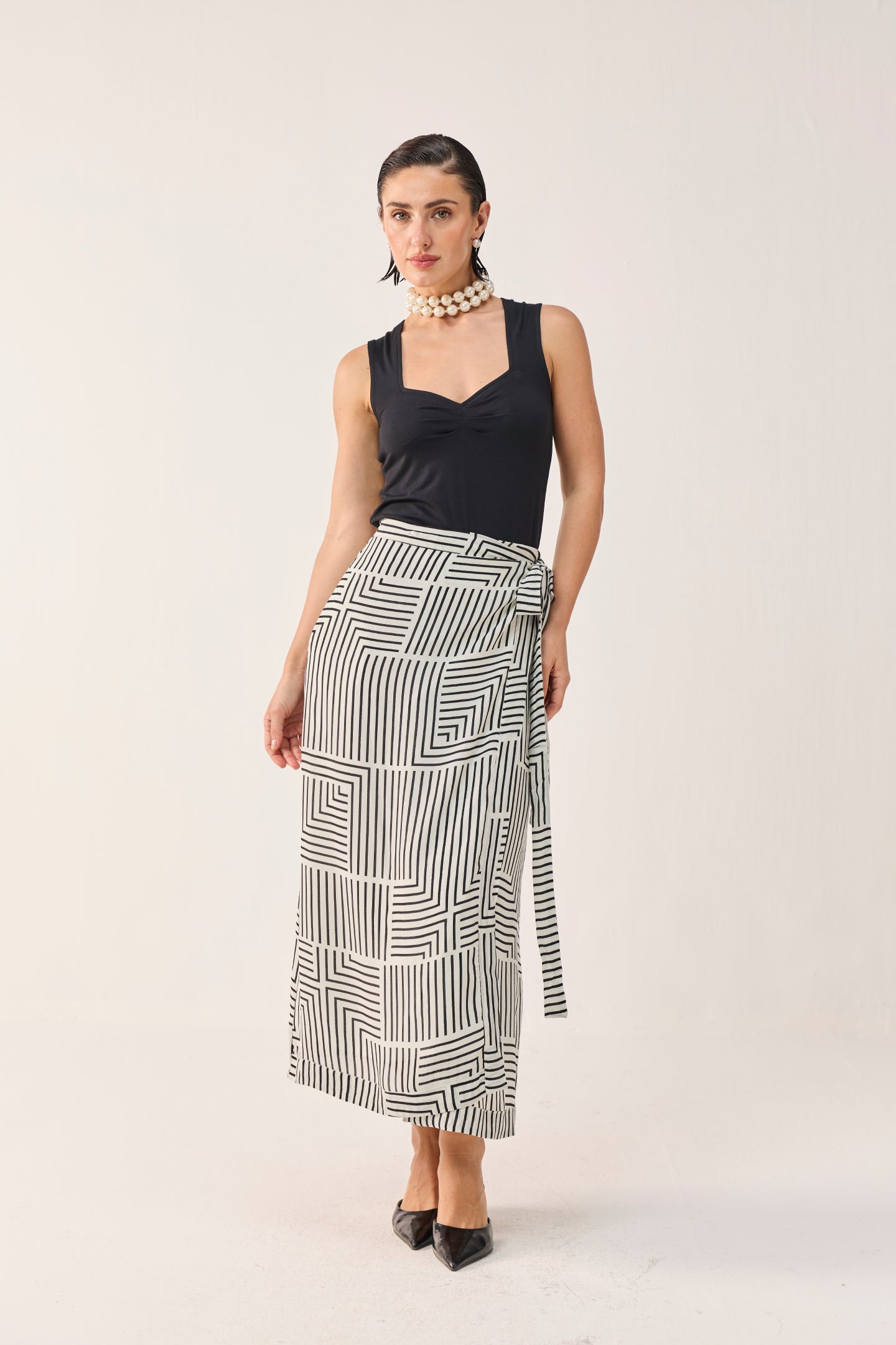 Front view of Reistor Regular Sweetheart Neck Top in Black paired with a black and white patterned midi skirt.