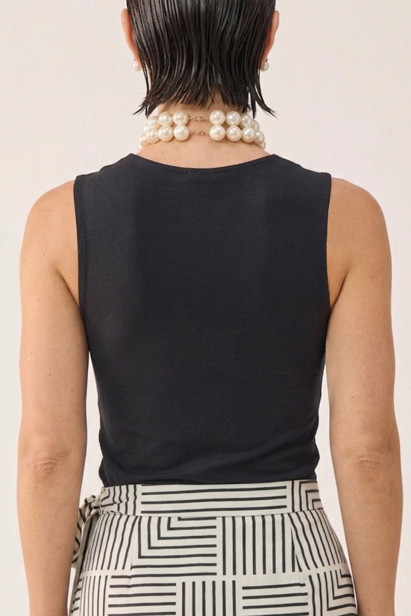 reistor Regular Sweetheart Neck Top in Black, sleeveless fitted top shown from the back, paired with a geometric print skirt for a chic minimalist look.