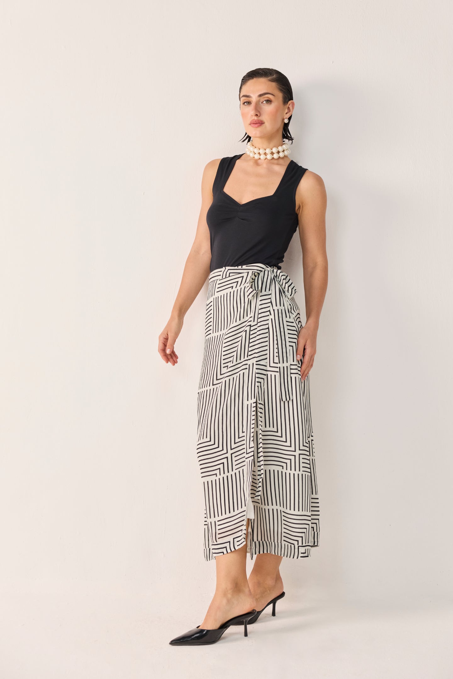 reistor Regular Sweetheart Neck Top in Black styled with a monochrome geometric wrap skirt, featuring a flattering fitted silhouette and elegant sleeveless design.