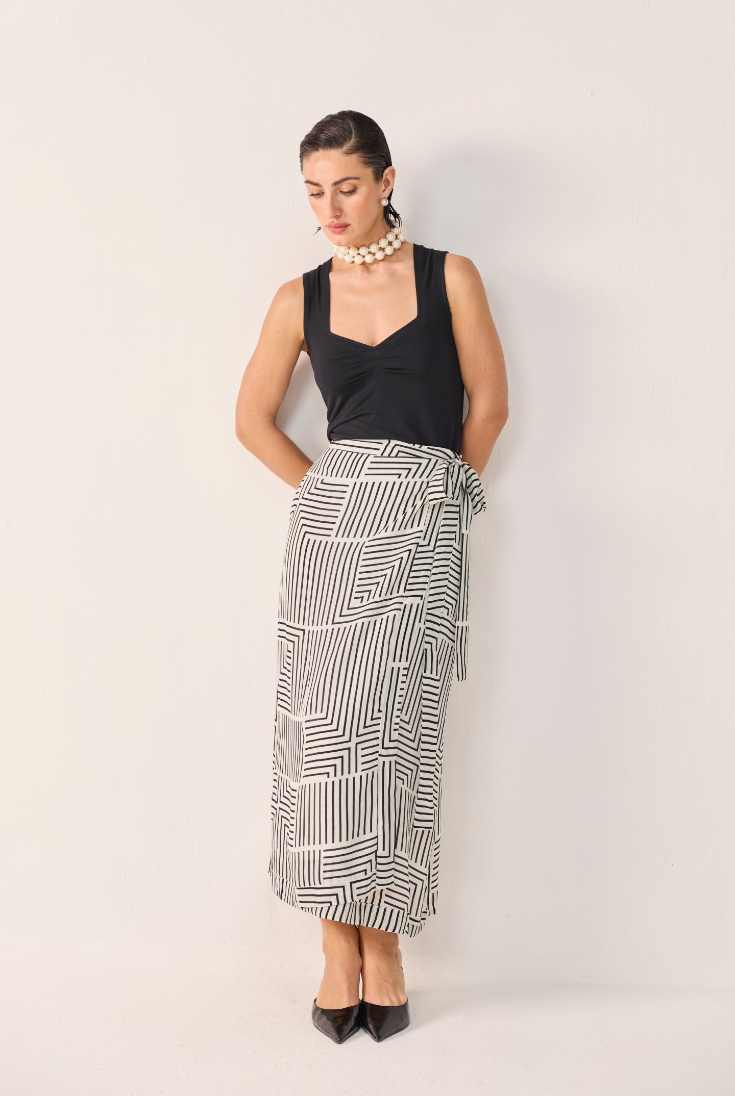 Model wearing Reistor's Regular Sweetheart Neck Top in Black, styled with geometric print wide-leg pants and pointed heels.