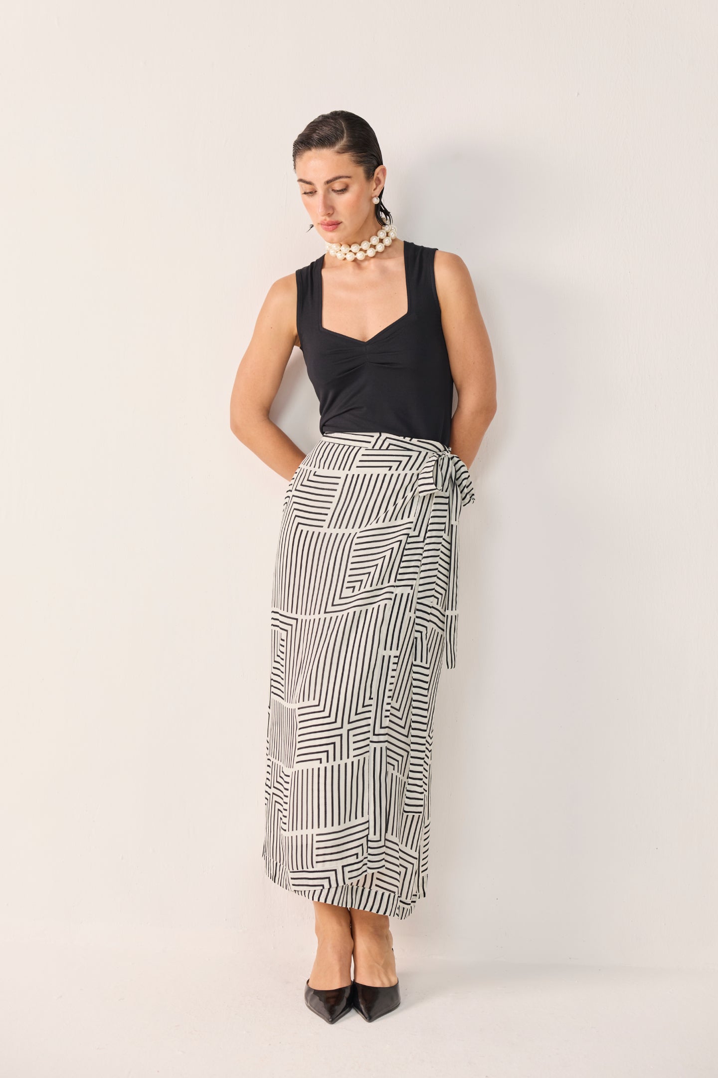 Model wearing Reistor's Regular Sweetheart Neck Top in Black, styled with geometric print wide-leg pants and pointed heels.