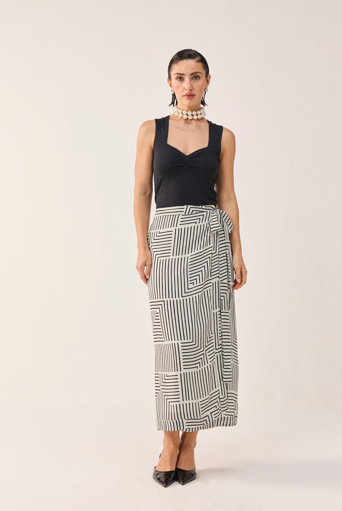 Reistor Regular Sweetheart Neck Top in Black styled with a monochrome geometric wrap skirt, offering a polished, modern look with timeless elegance.