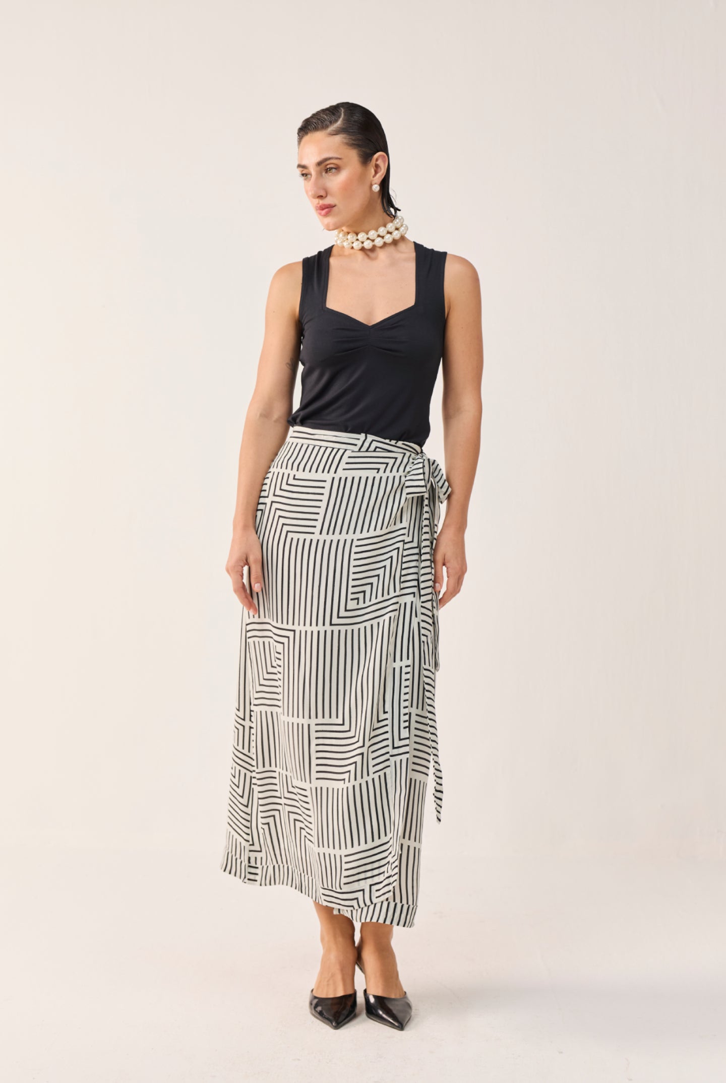 Model wearing Reistor Regular Sweetheart Neck Top in Black with a black and white printed wrap skirt.