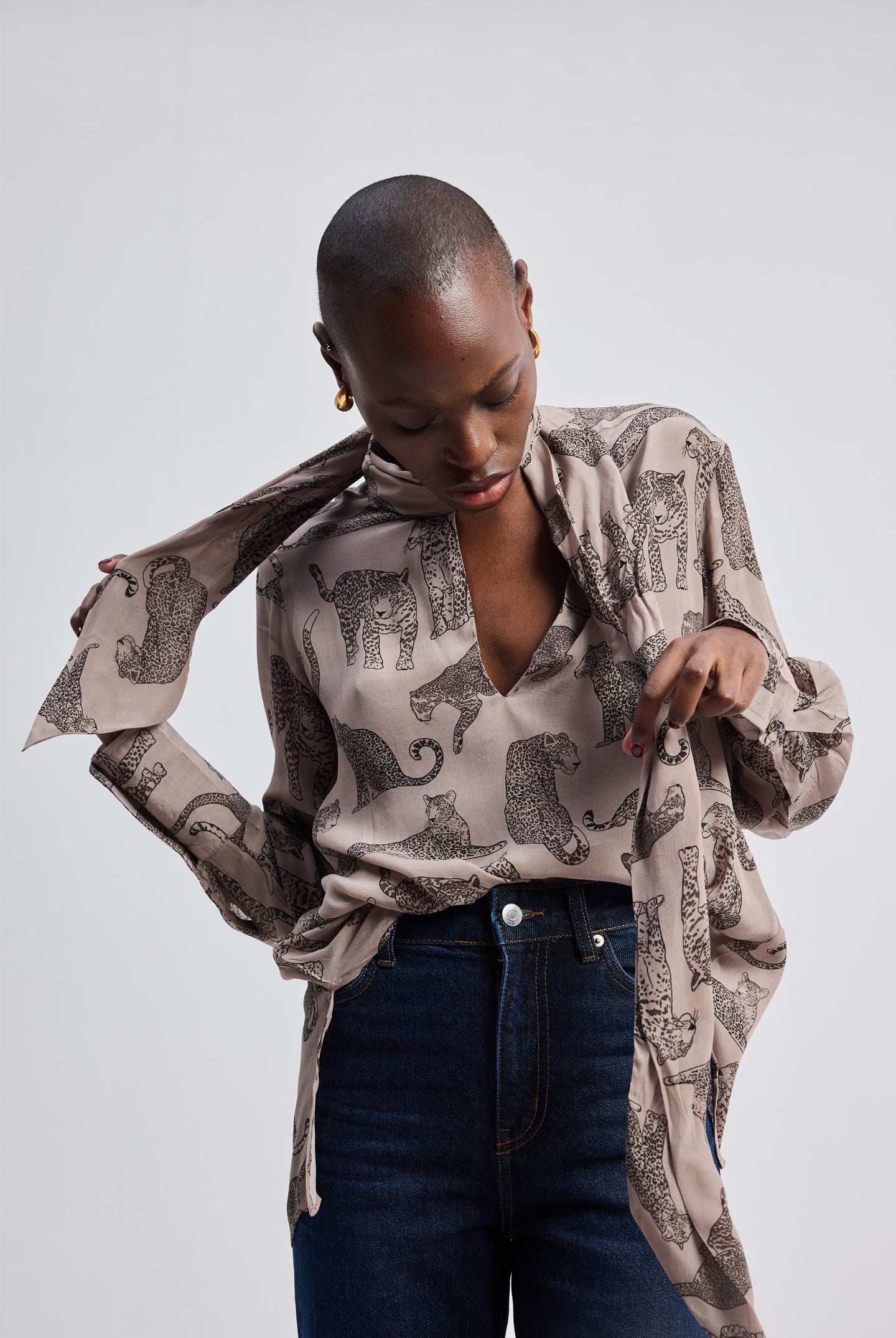 Model wearing a Reistor Relaxed-Fit Top with Front-tie in Animal Print, a sustainable long-sleeve V-neck top featuring a hand-drawn pattern.