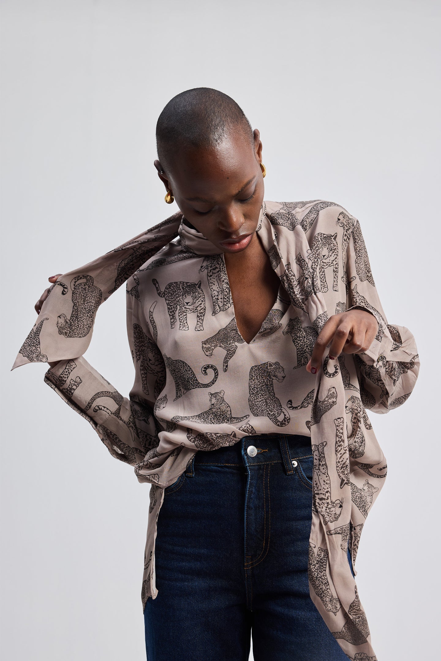 Model wearing a Reistor Relaxed-Fit Top with Front-tie in Animal Print, a sustainable long-sleeve V-neck top featuring a hand-drawn pattern.