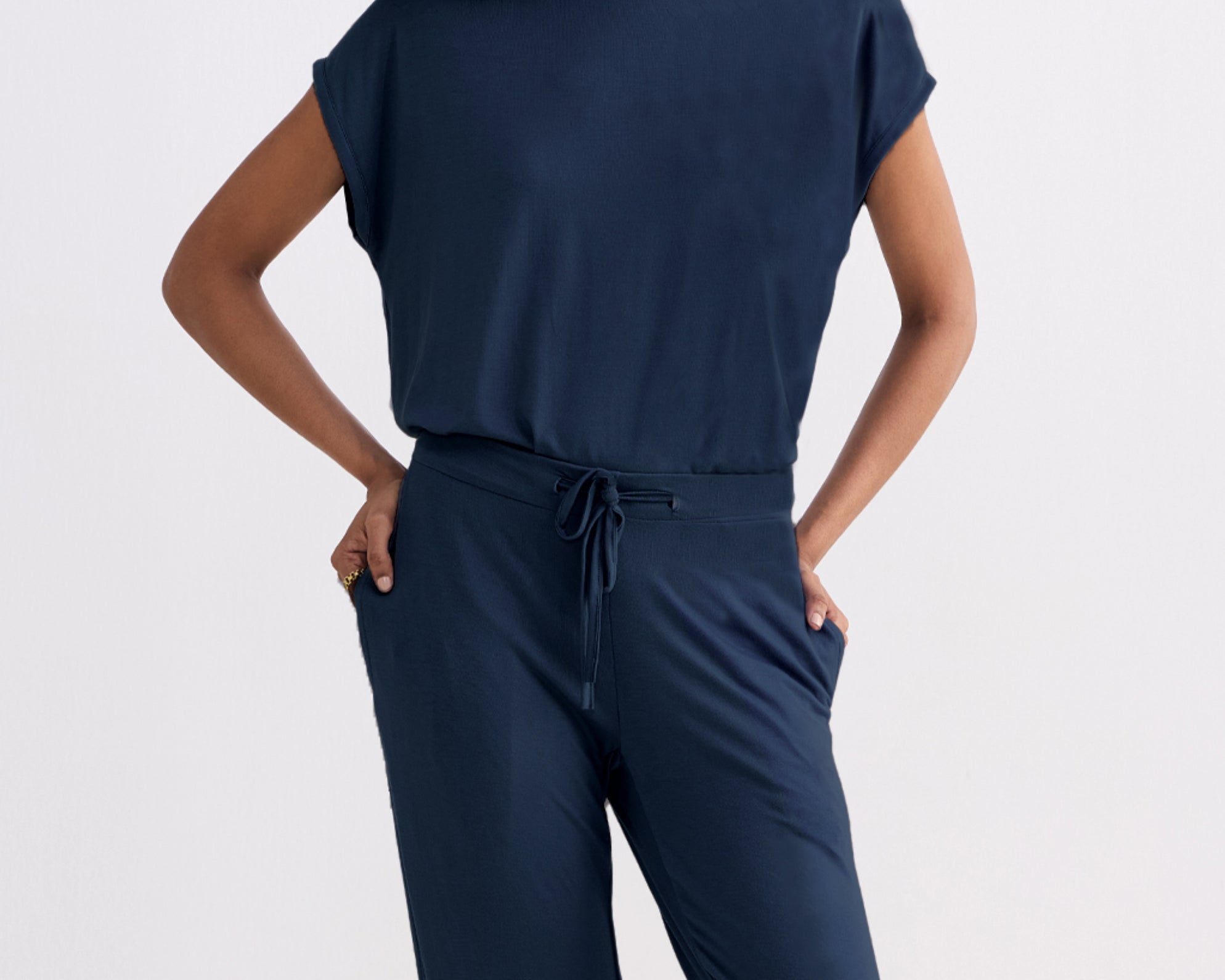 Person wearing a navy blue outfit with a plain background