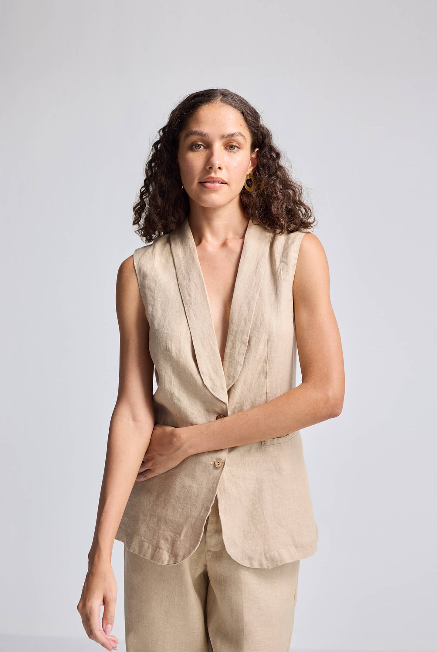 Close-up view of model wearing the Reistor Sleeveless Hemp Jacket in beige, featuring a deep V-neckline, tailored silhouette, and sustainable hemp fabric.
