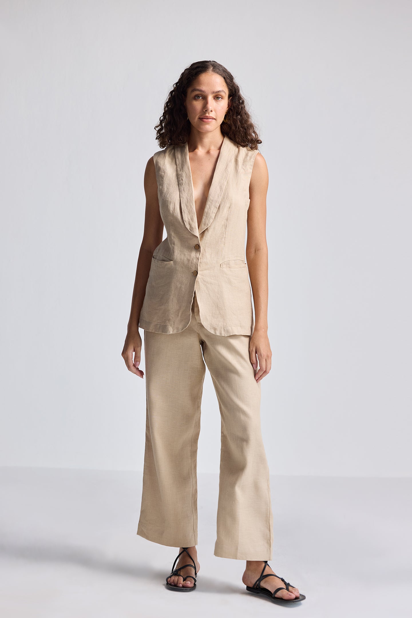 Full-length front view of model wearing Reistor Sleeveless Hemp Jacket Set in natural beige, featuring a sleeveless tailored hemp jacket paired with wide-leg hemp trousers for sustainable women’s fashion.