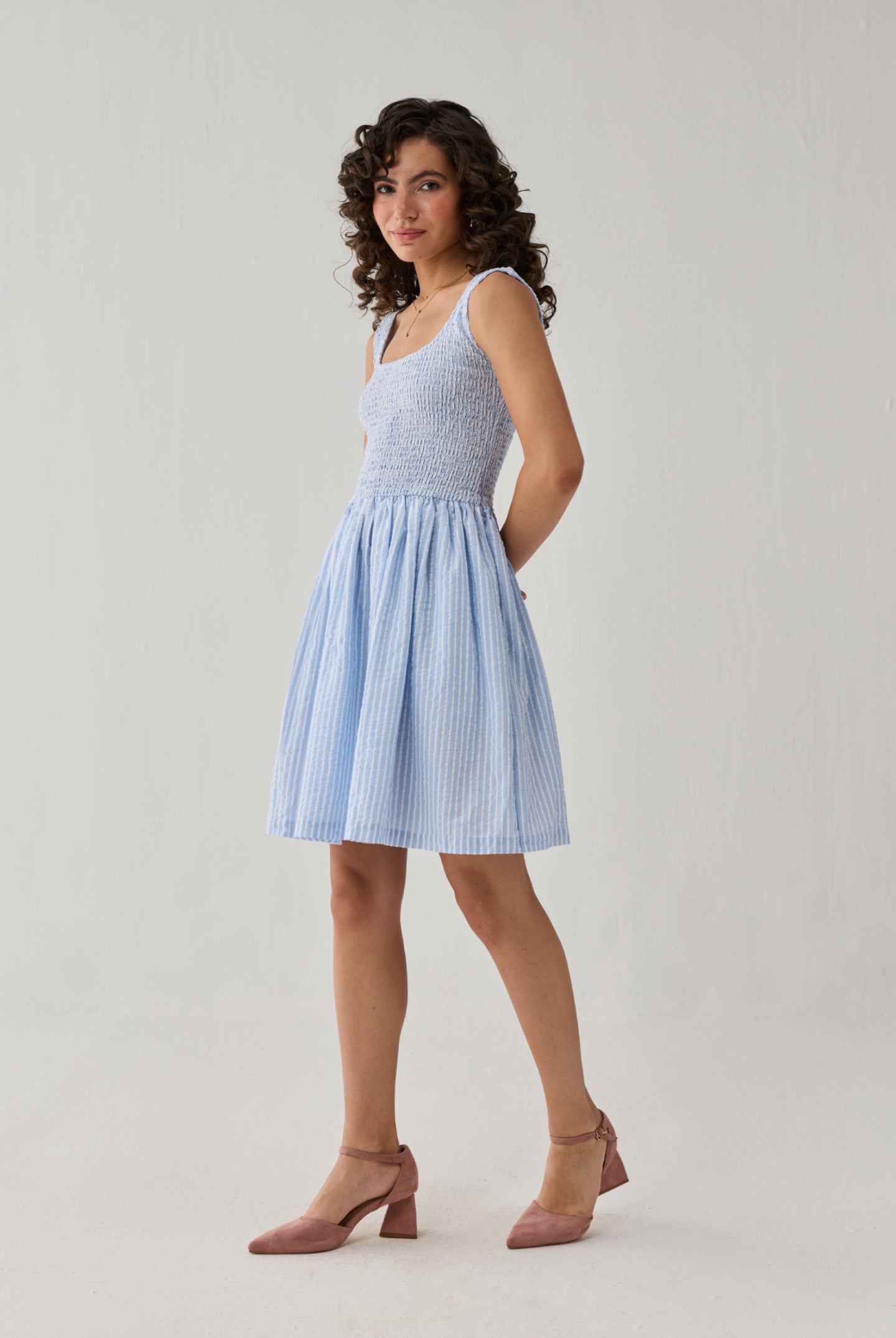 Smocked Short Dress in Blue Stripes showcasing a square neckline, gathered waistline, and airy skirt for timeless casual elegance.