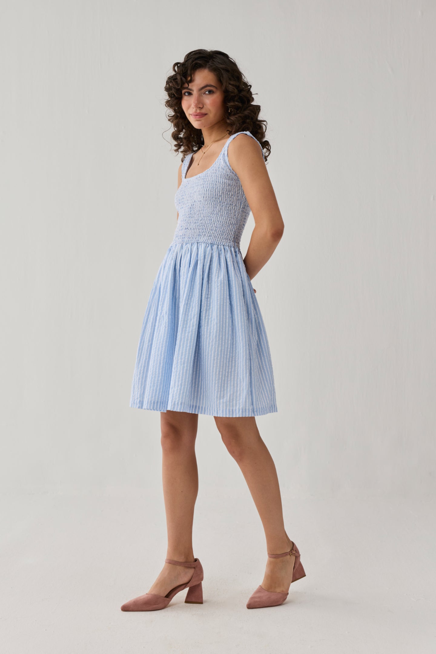 Smocked Short Dress in Blue Stripes showcasing a square neckline, gathered waistline, and airy skirt for timeless casual elegance.