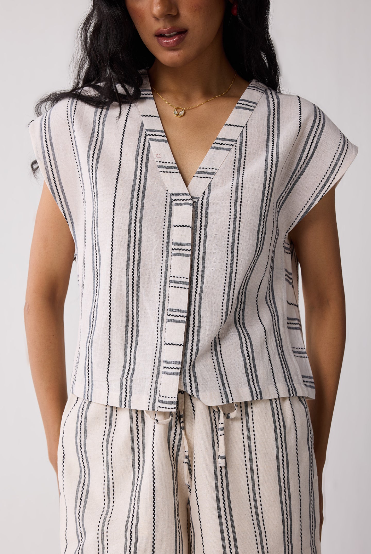 Close-up front view of Striped Matching Set with Wide-Leg Pants and V-neck Top for women, showcasing the V-neckline, button detail, and vertical stripe pattern.