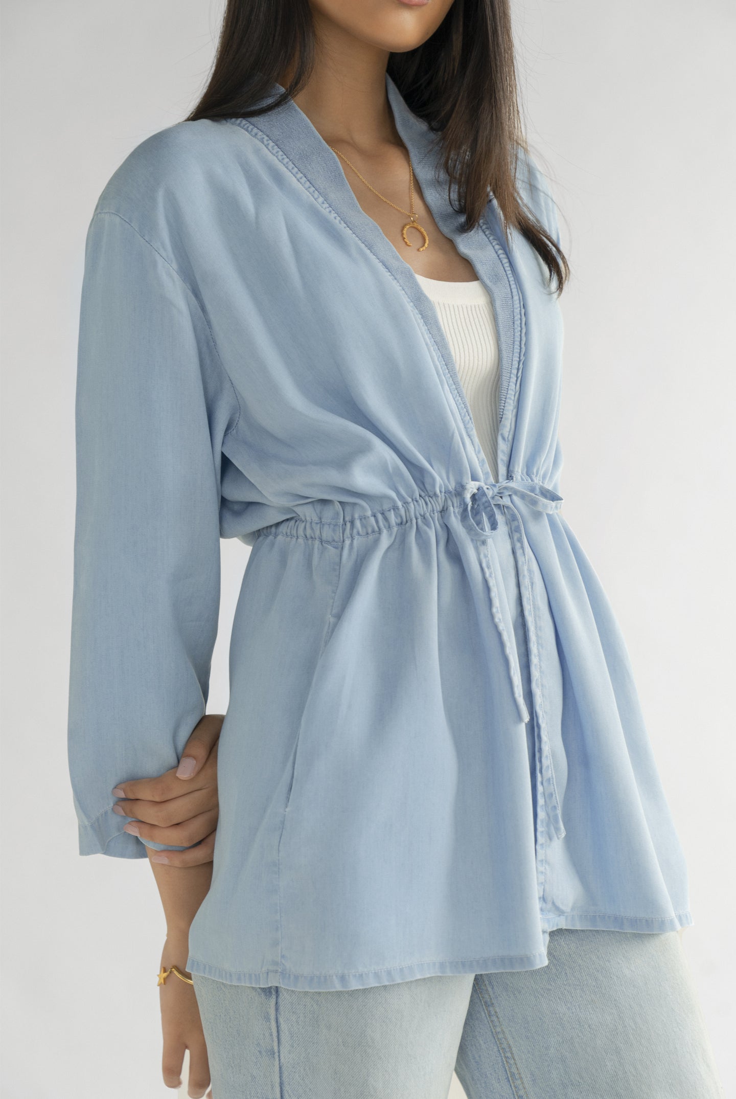 Reistor Travel Light Denim Jacket in Ocean Blue with a flattering drawstring waist, open-front design and soft denim fabric for versatile everyday wear.