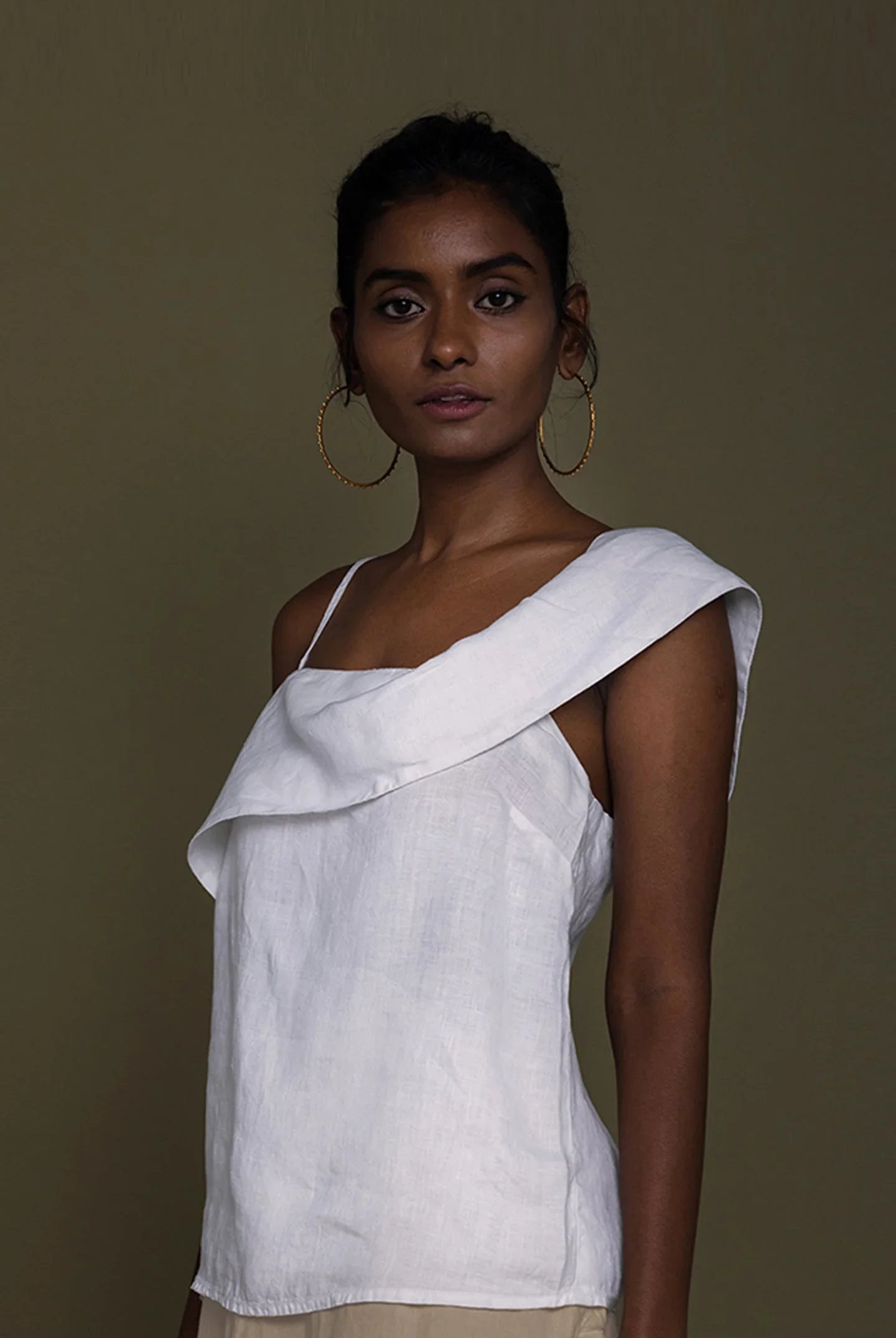 Woman wearing a white top with a brown background