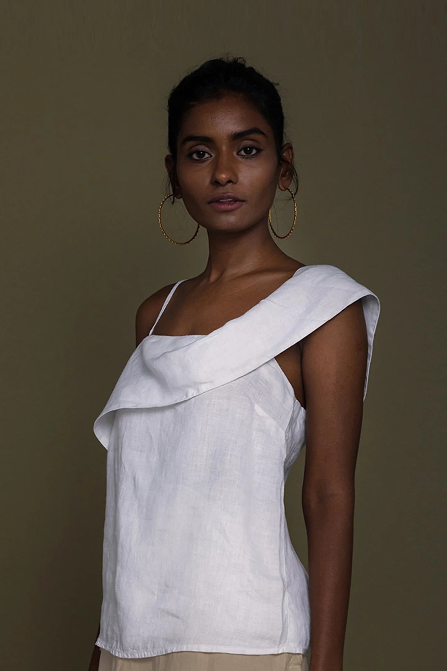Woman wearing a white top with a brown background