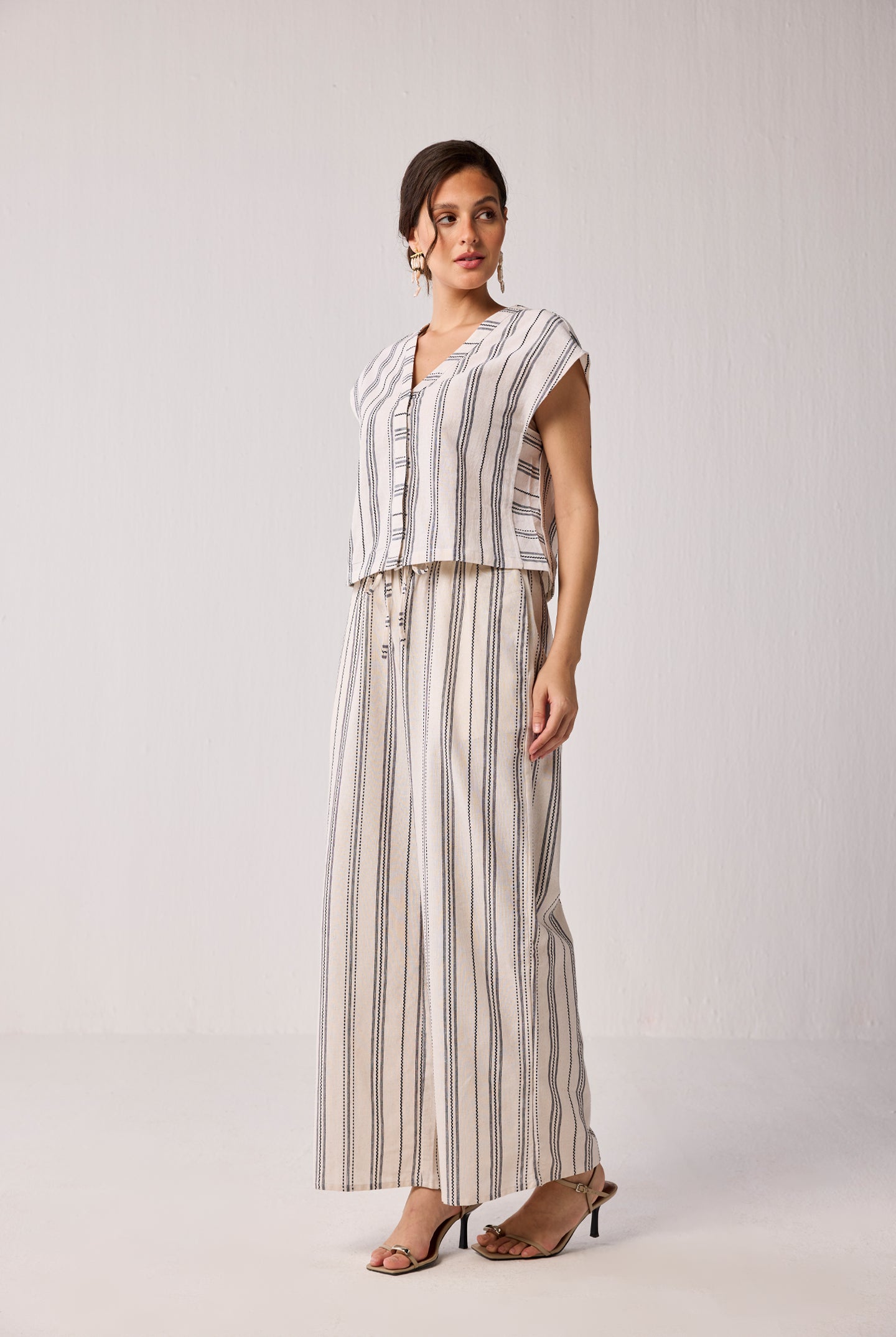 Model wearing Reistor Wide-leg Drawstring Pants in Stripes, featuring a relaxed wide-leg silhouette with vertical striped pattern and drawstring waist.
