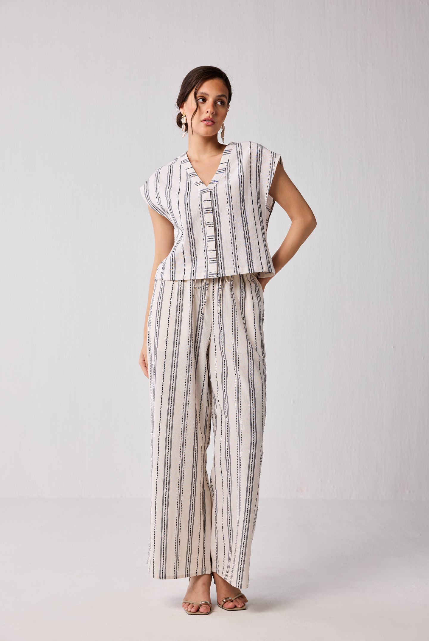Model wearing Reistor Wide-leg Drawstring Pants in Stripes with a matching striped top, featuring a relaxed fit and breathable fabric.