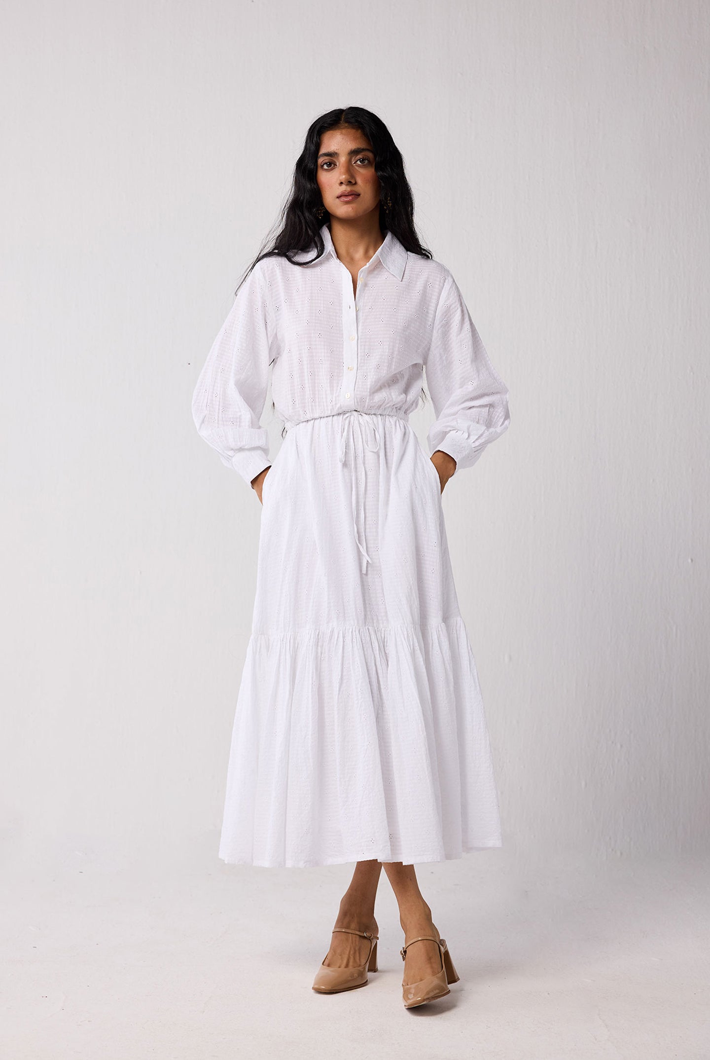 Woman wearing a white dress with a plain background