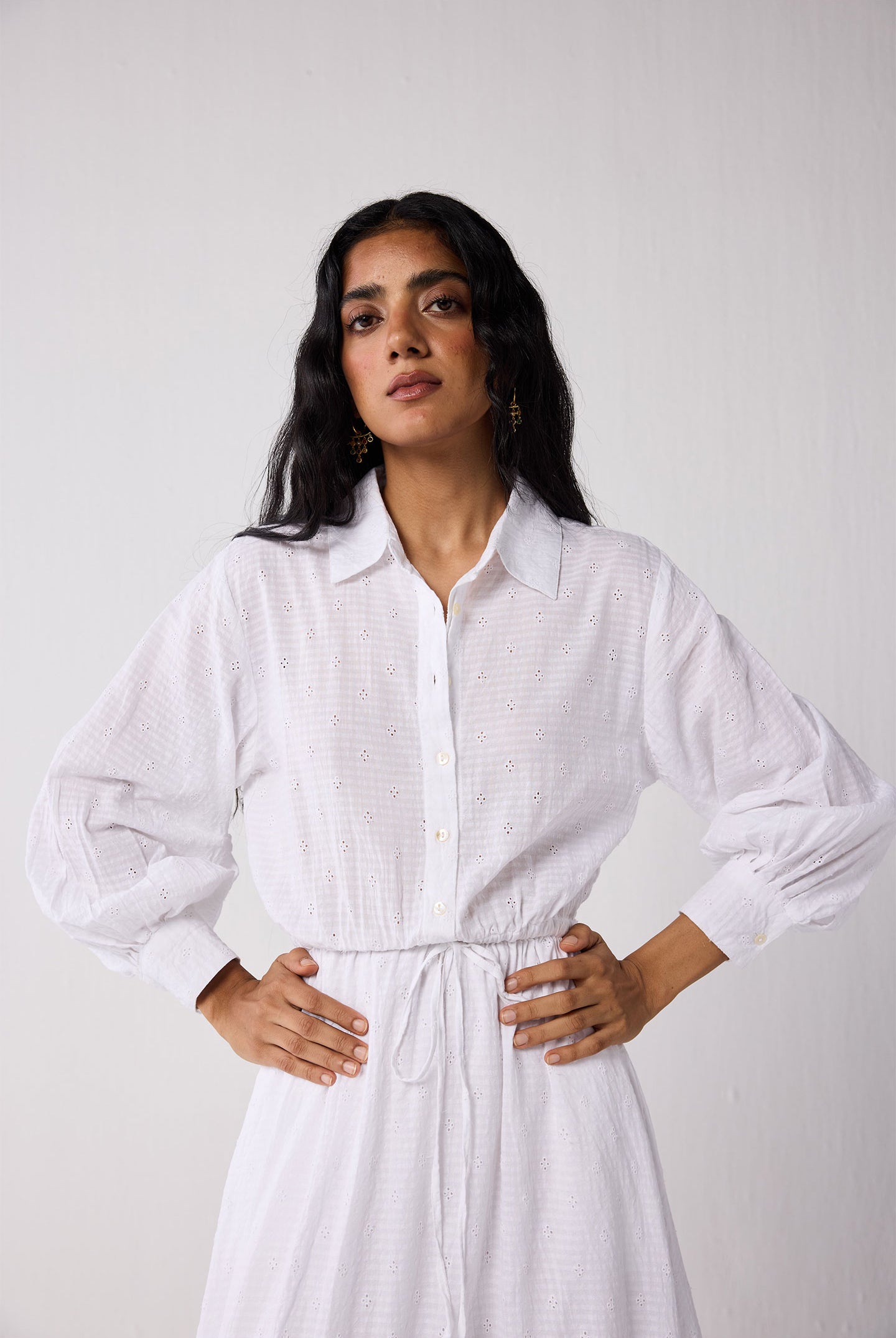 Woman wearing a white dress against a plain background
