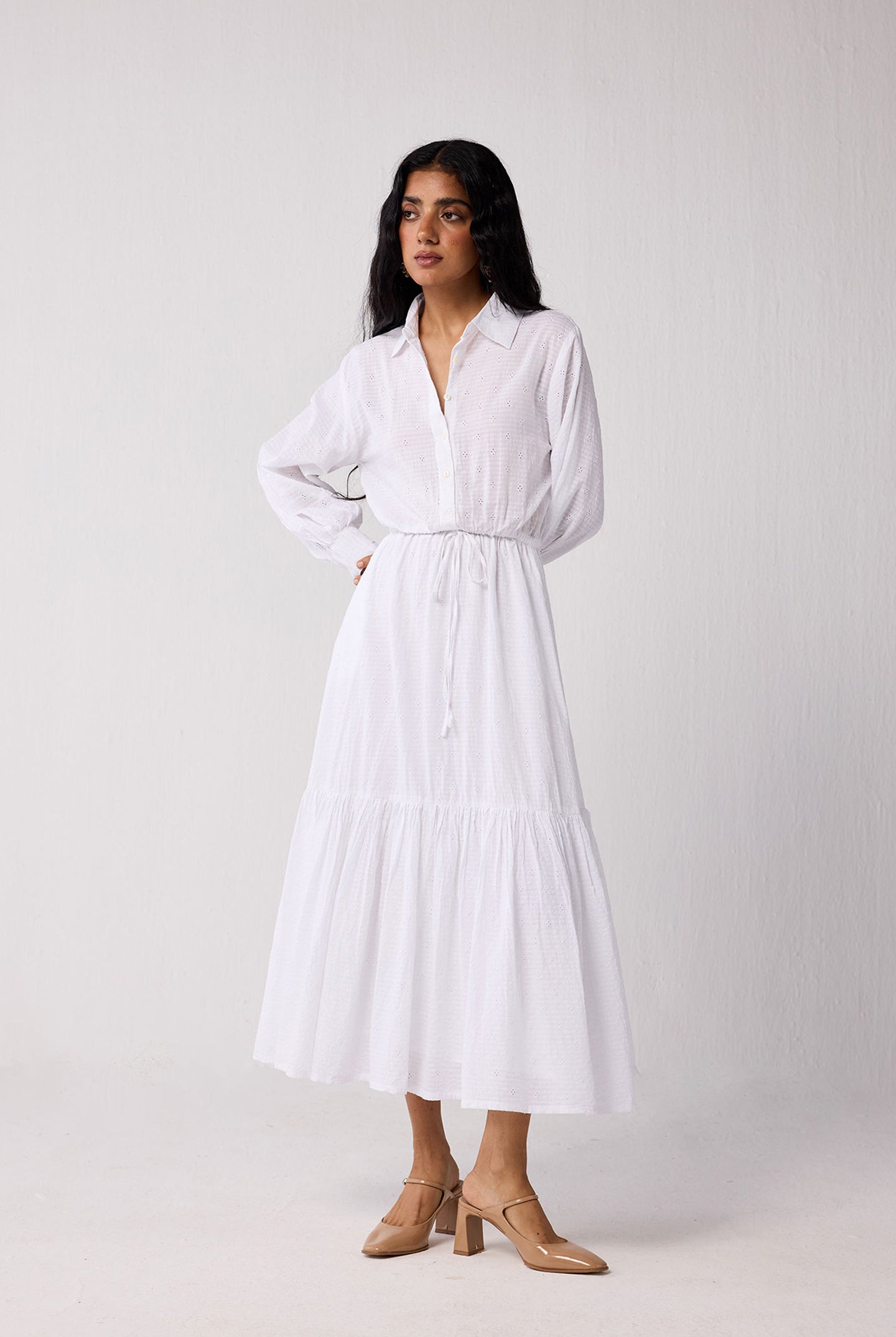 Woman wearing a white dress against a plain background