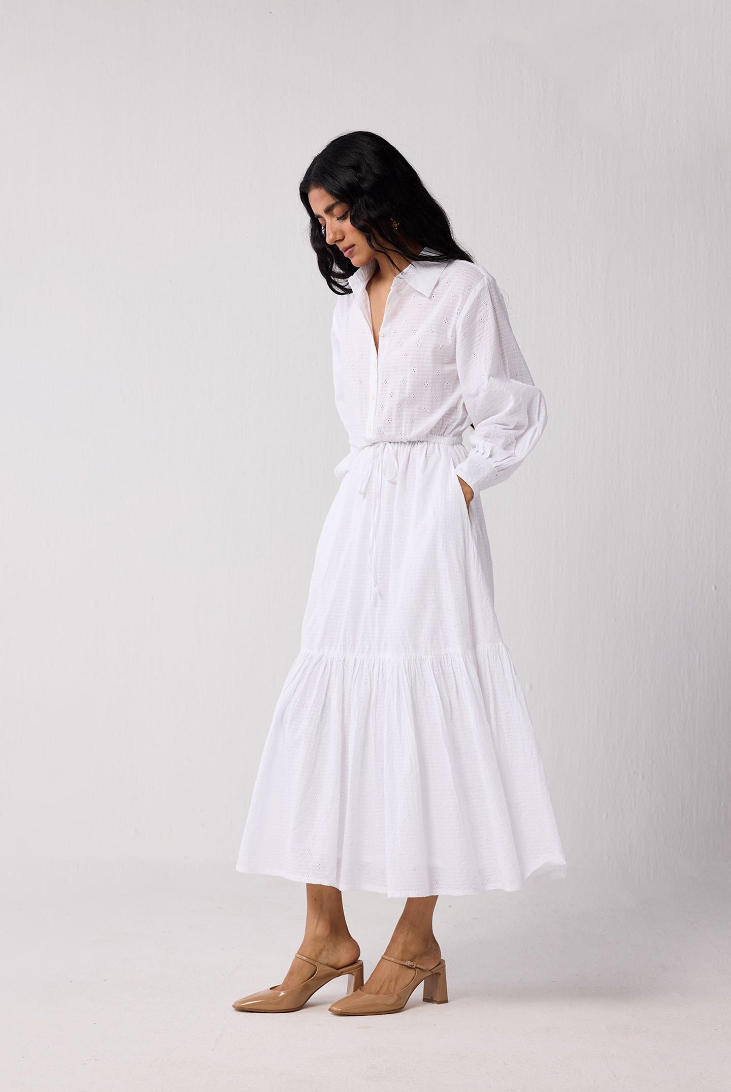 Woman wearing a white dress against a plain background