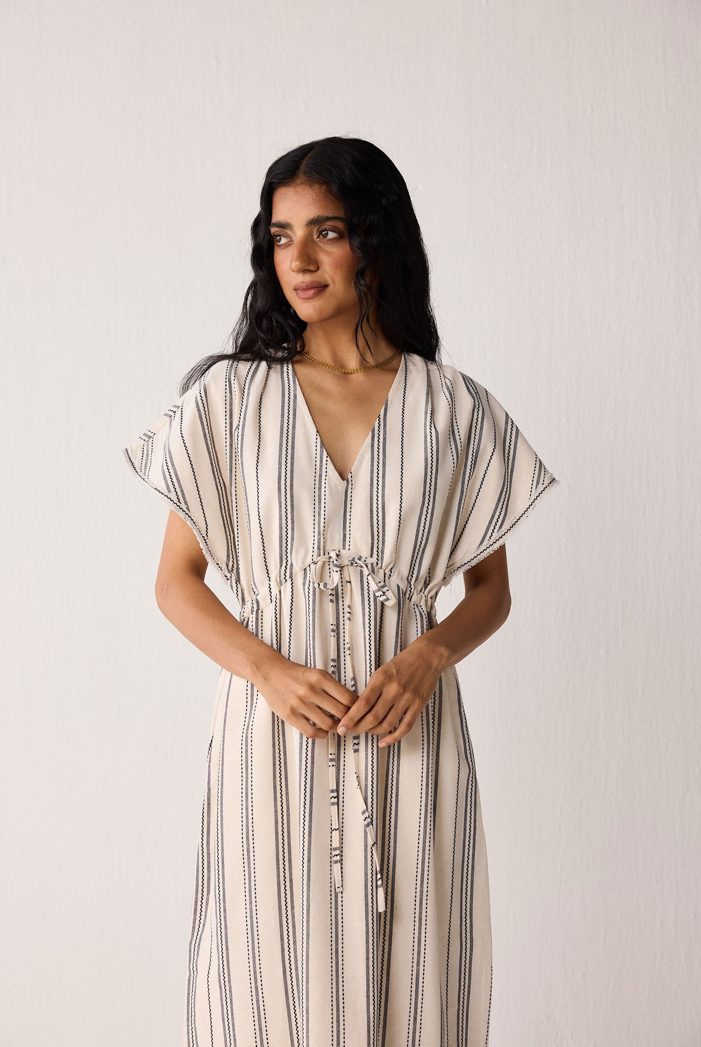 Woman wearing a striped dress against a plain background