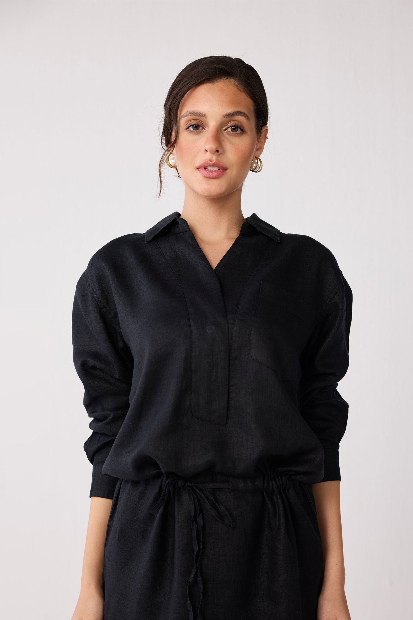 Woman wearing a black dress against a white background