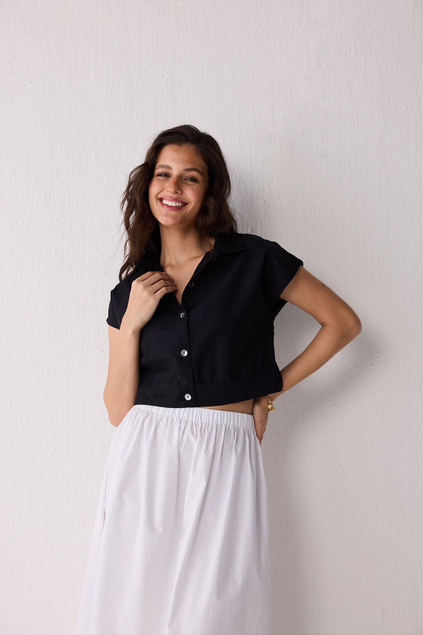 Woman wearing a black top against a plain background