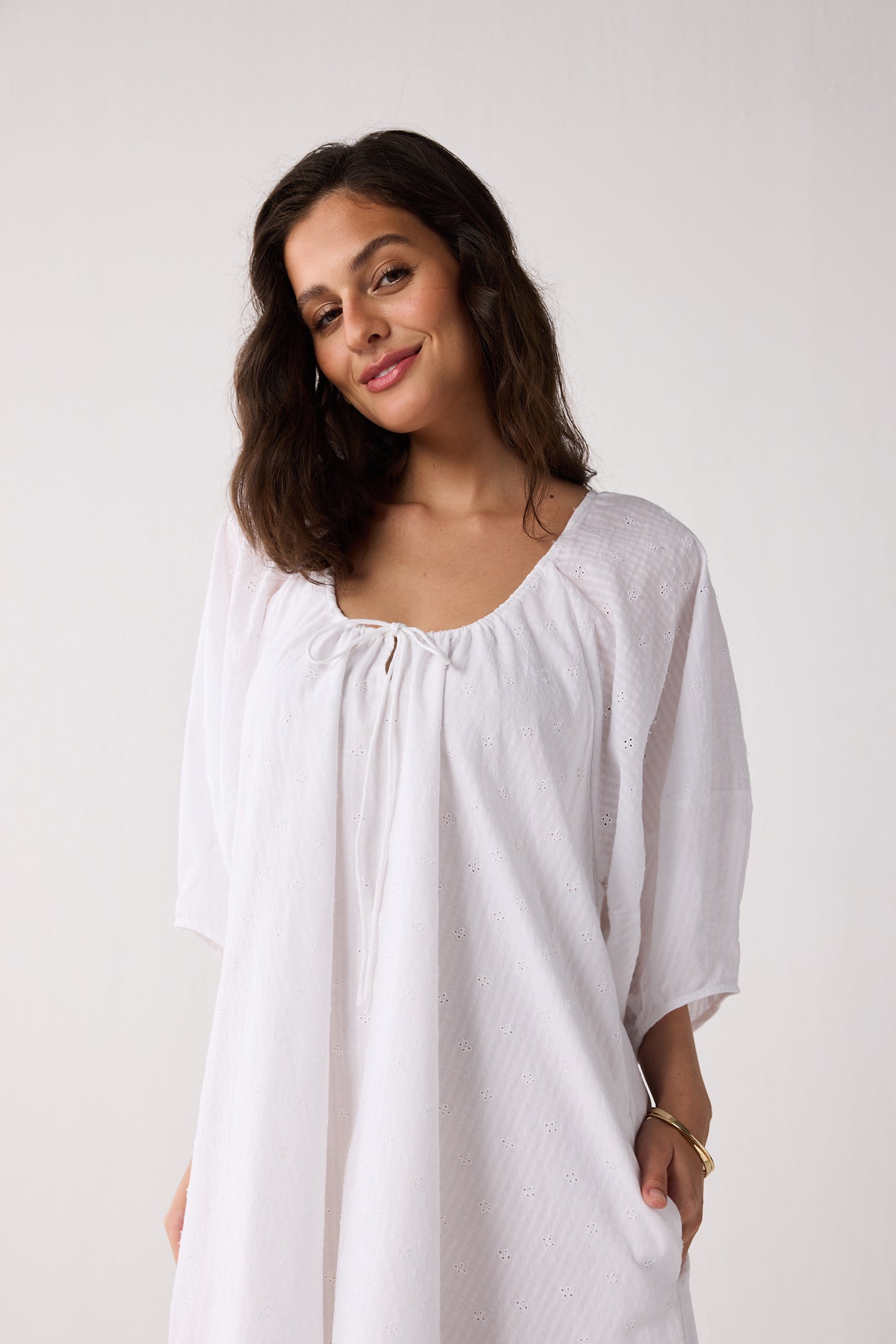 Woman wearing a white blouse against a plain background